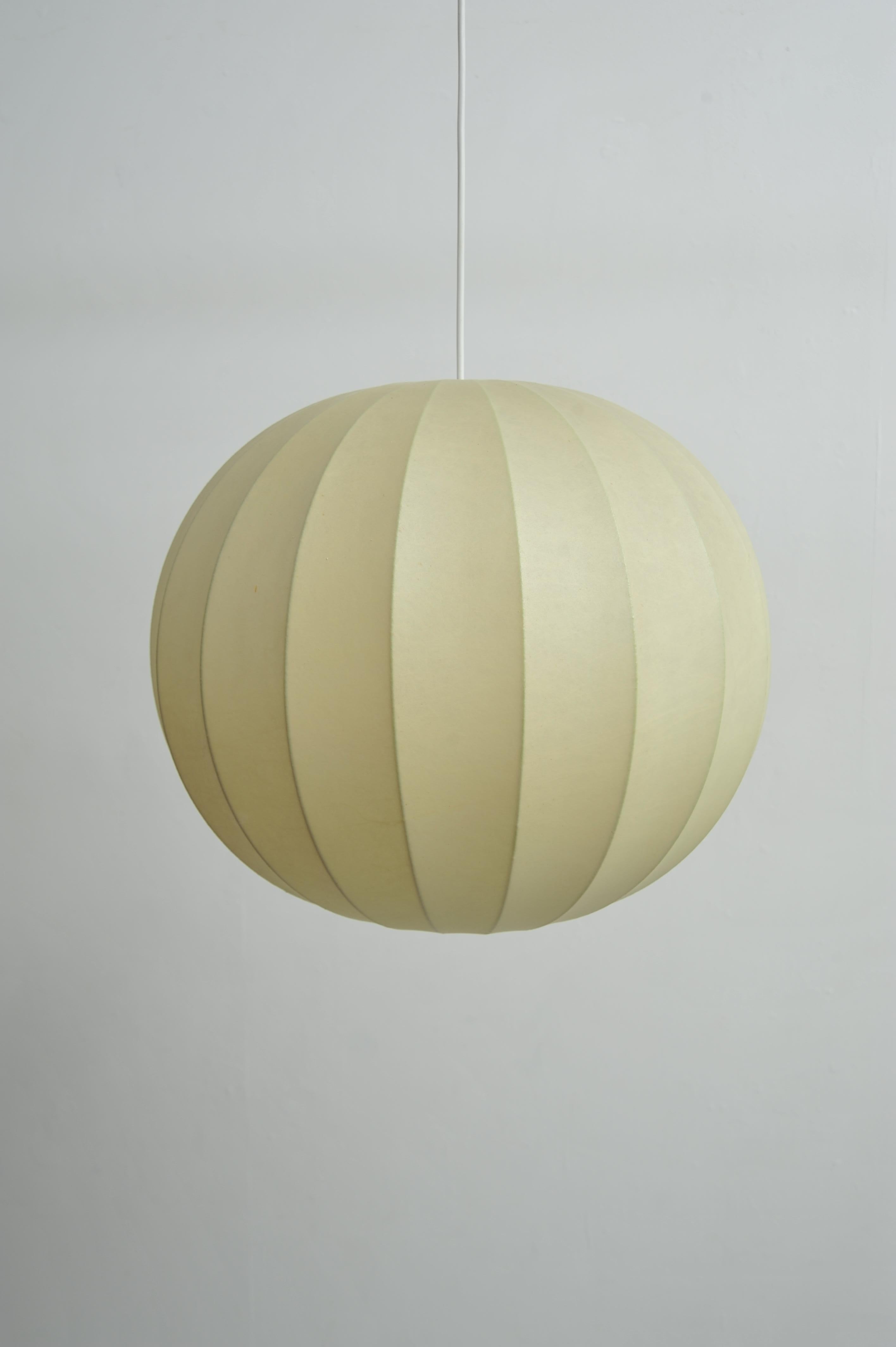 Diese Cocoon Hängelampe aus den 1960er Jahren verkörpert den Mid-Century Vintage-Stil und ist ein zeitloser Hingucker. Die Lampe ist aus Metall gefertigt und in Cremeweiß gehalten, was ihr eine elegante und schlichte Optik verleiht. Leichte