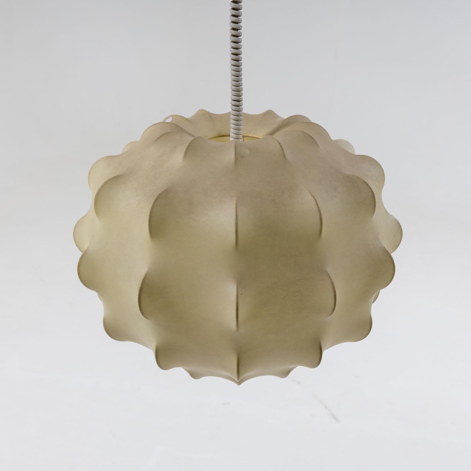 A substantial Cocoon hanging lamp in the style of Tobia Scarpa. The lamp is comprised of a curved wire frame and is enveloped in a translucent layer of resin, casting a warm and inviting glow. 