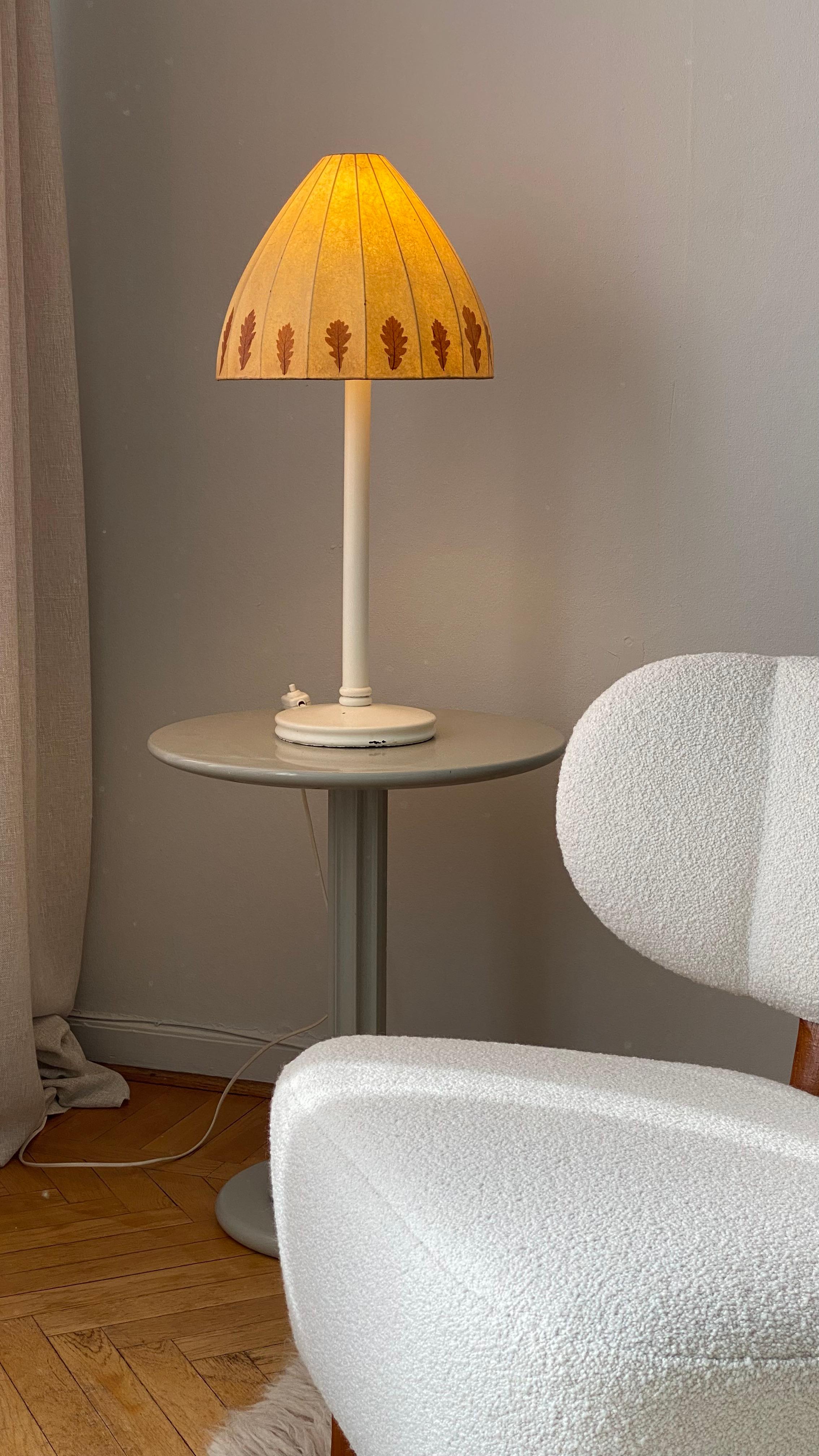 This unusual table lamp by Hans-Agne Jakobsson is a unique product with a white painted wooden base and a shade made of resin-like material, decorated with real leaves. It gives a fantastic glow and is definitely an unusual and beautiful addition to