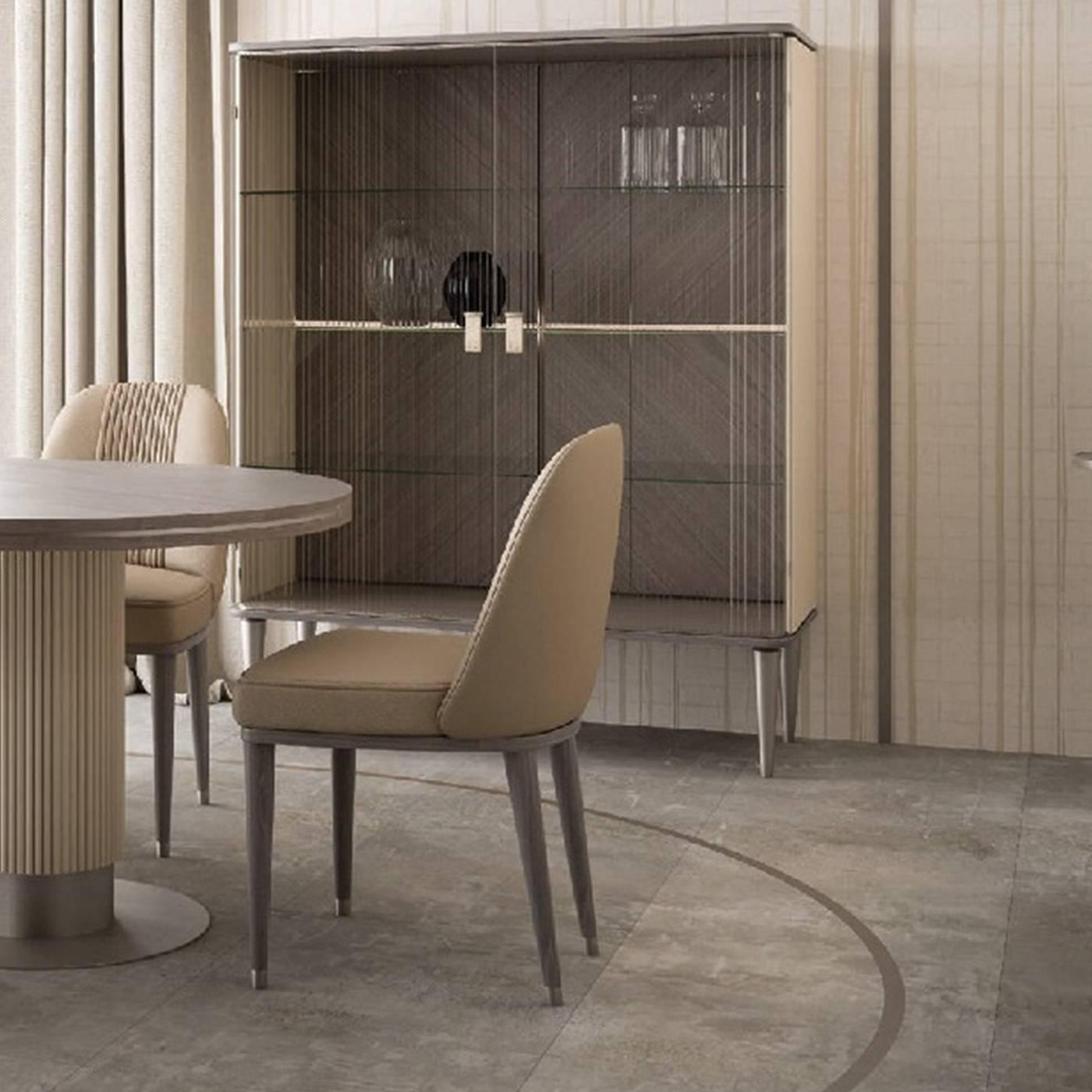 A remarkable union of expert craftsmanship and innovative aesthetic, this unique cabinet exudes elegance and sophistication. Standing on four conical wood feet with a gray finish, the lacquered beige wood cabinet features a sophisticated pattern