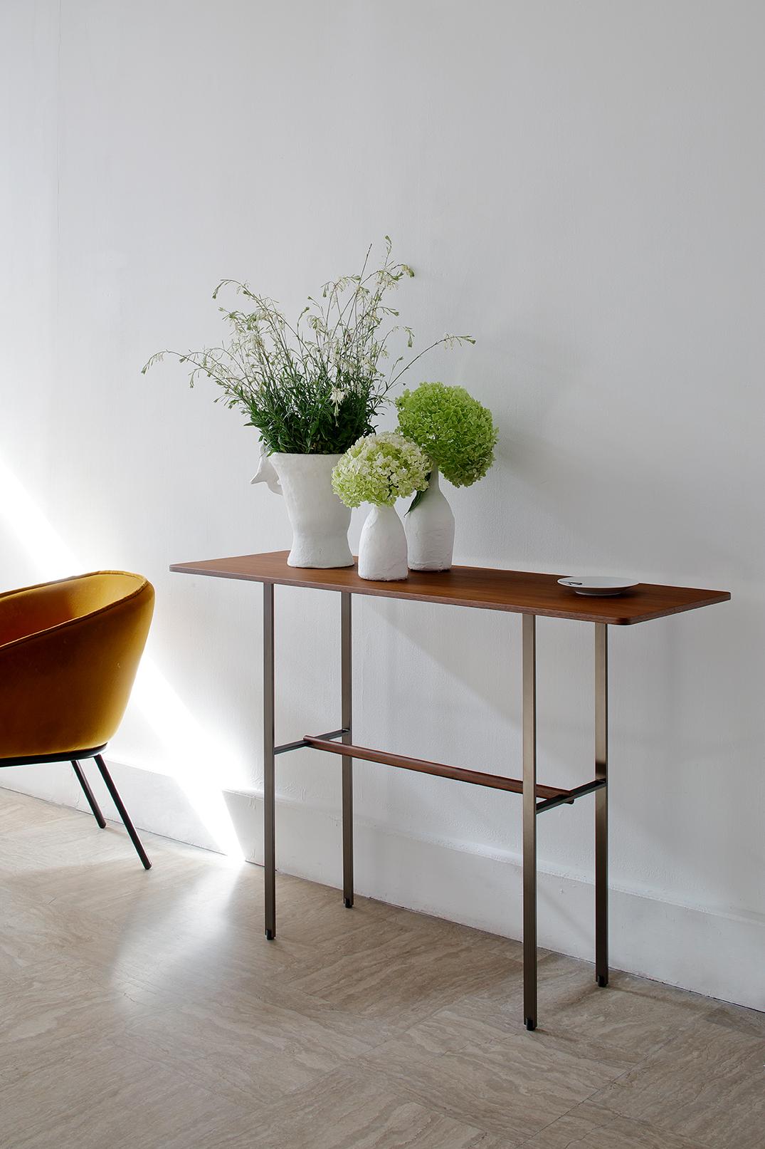 Console, top in walnut vener top or black oak veneer. Structure in bronze
lacquered metal with a solid walnut crossbar.
Dimensions: 120x40xH80cm