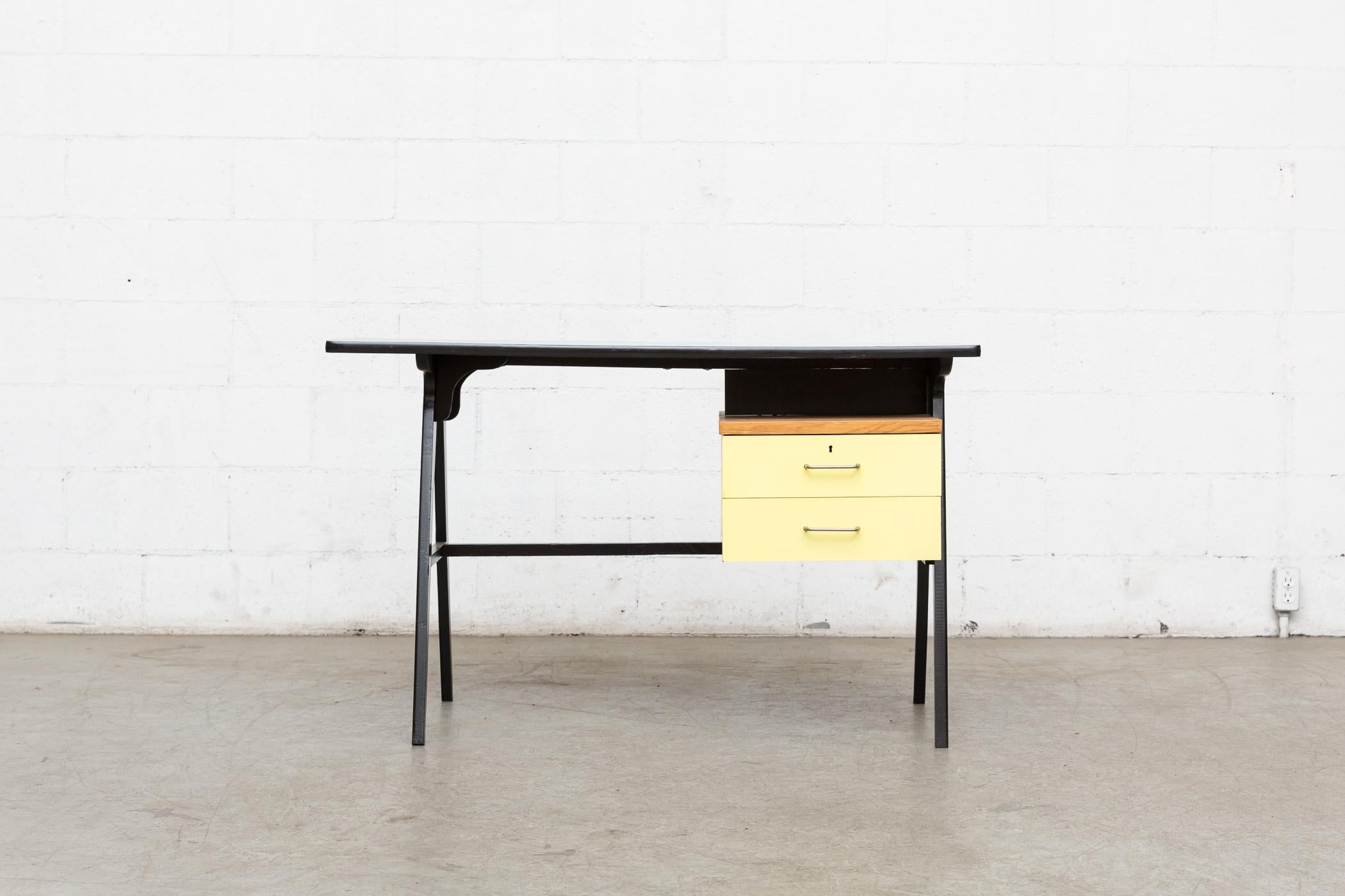 Midcentury wood writing desk with original sky blue formica top and yellow formica faced drawers with brushed chrome hand pulls. Wood frame is painted black. Original condition with visible wear. and Patina.