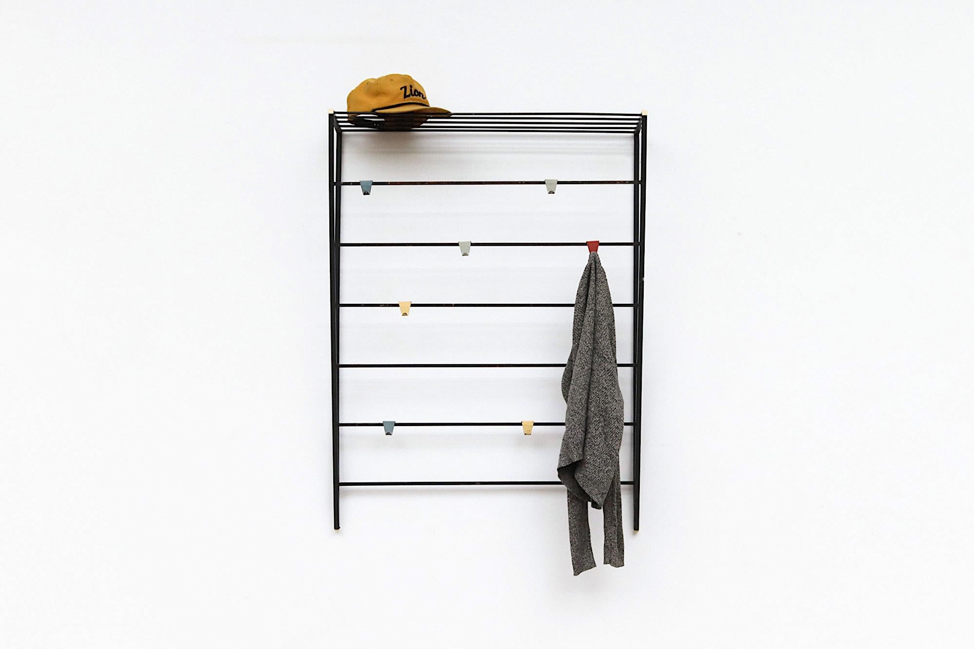 Triangular shaped black enameled metal wall mount coat rack with multi-colored hooks, and built in hat rack. In original condition with visible wear, including rust. Wear is consistent with its age and use. Others available in varying sizes