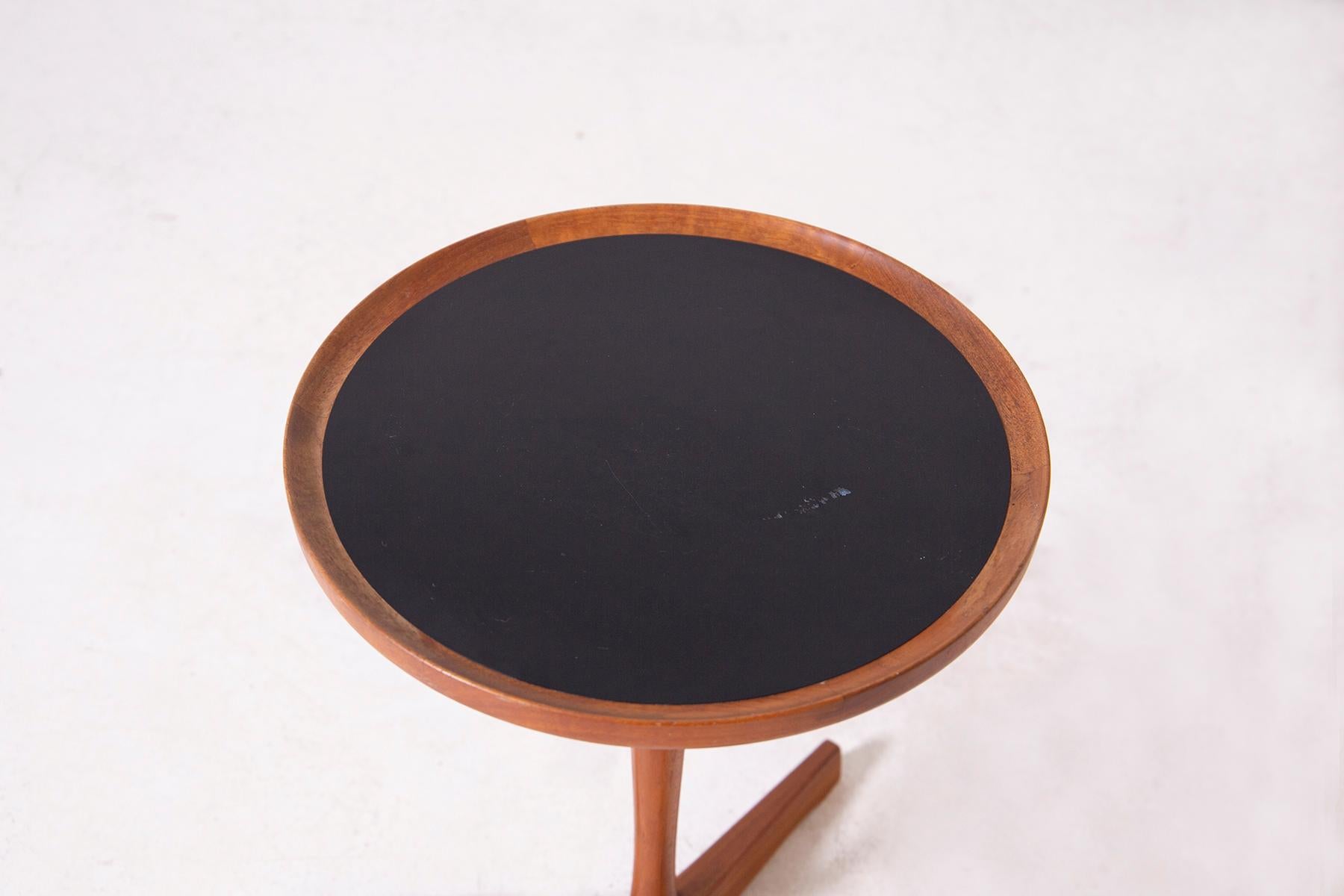 Small teak coffee table by Hans C. Andersen from the 1950s. The coffee table has a single pendant with three support feet, Teak tripod base frame with original black melamine top. The special feature of the small table is its beautiful wood joints.