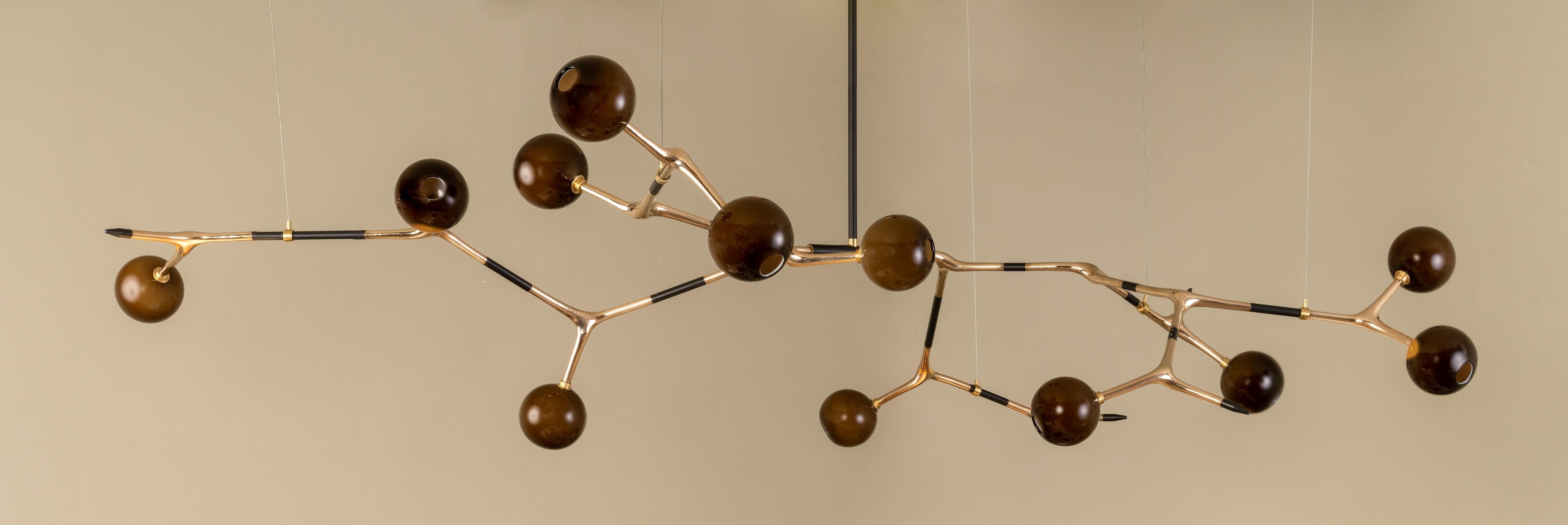 Coffee and Polished Bronze Mantis 13 Pendant Lamp by Isabel Moncada
Dimensions: Ø 280 x H 145 cm.
Materials: Cast bronze, blown glass and turned brass.
Weight: 17 kg.

Just like the insect it shares its name with, this piece is elongated with fluid