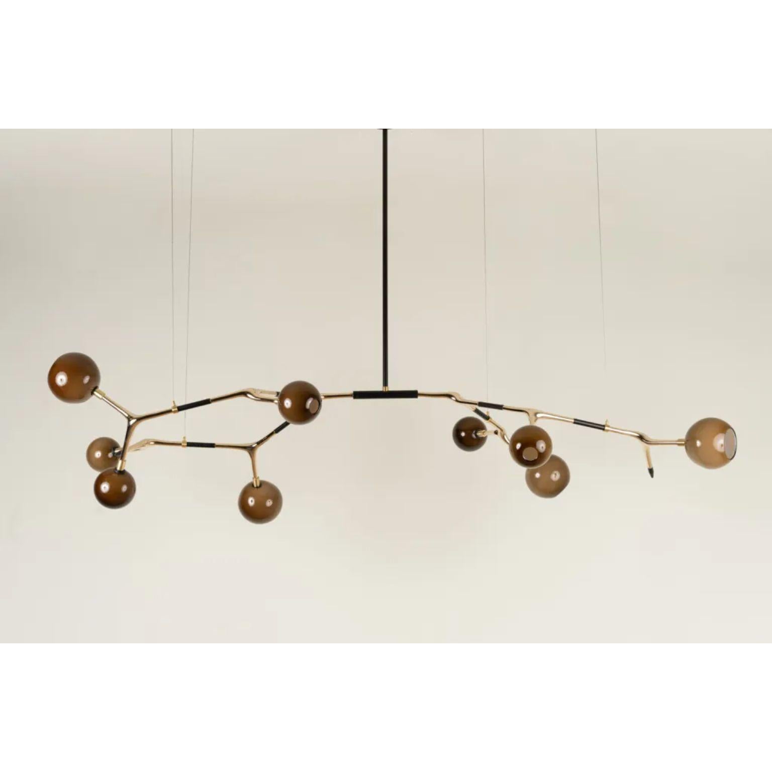 Coffee and Polished Bronze Mantis 9 Pendant Lamp by Isabel Moncada
Dimensions: D 100 x W 190 x H 110 cm.
Materials: Cast bronze, blown glass and turned brass.

Mantis 9, discreet and elegant with measured dimensions. For a medium and sober table,