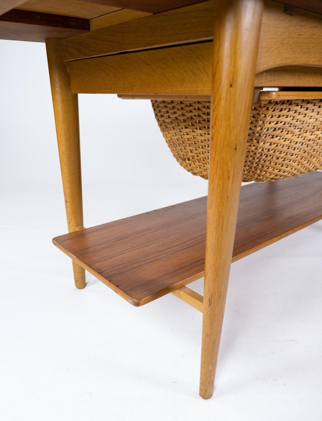 Cette table à café et à couture incarne l'éthique du design danois des années 1960, alliant fonctionnalité et esthétique élégante. Fabriqué à partir d'une combinaison de chêne et de teck, il se targue d'une fusion harmonieuse de matériaux