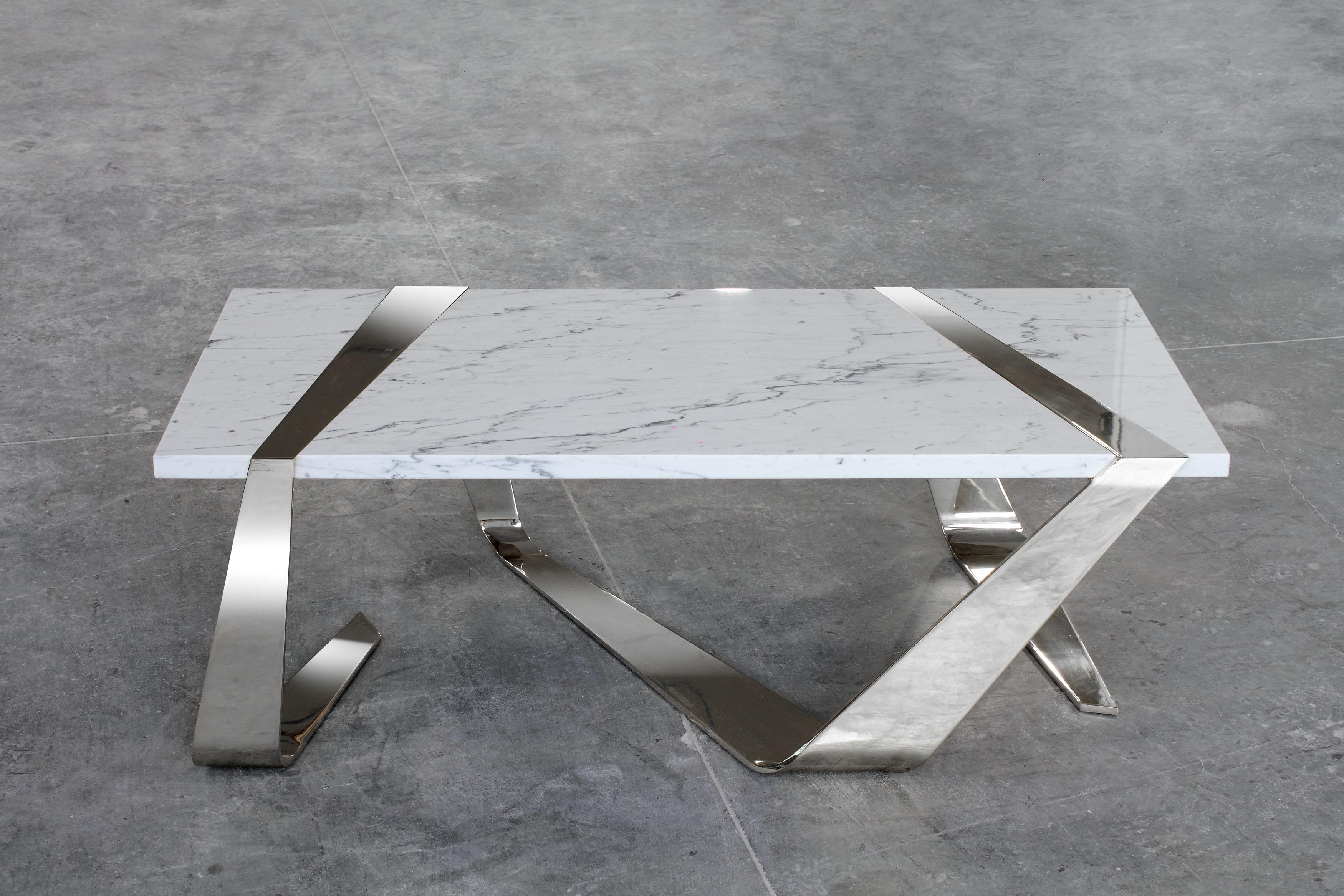 The 'Già-cinto' coffee table is characterized by a mirror-polished stainless steel structure which, like a ribbon, wraps and supports a precious slab of Carrara white marble which serves as a table top. The stainless steel structure is welded and