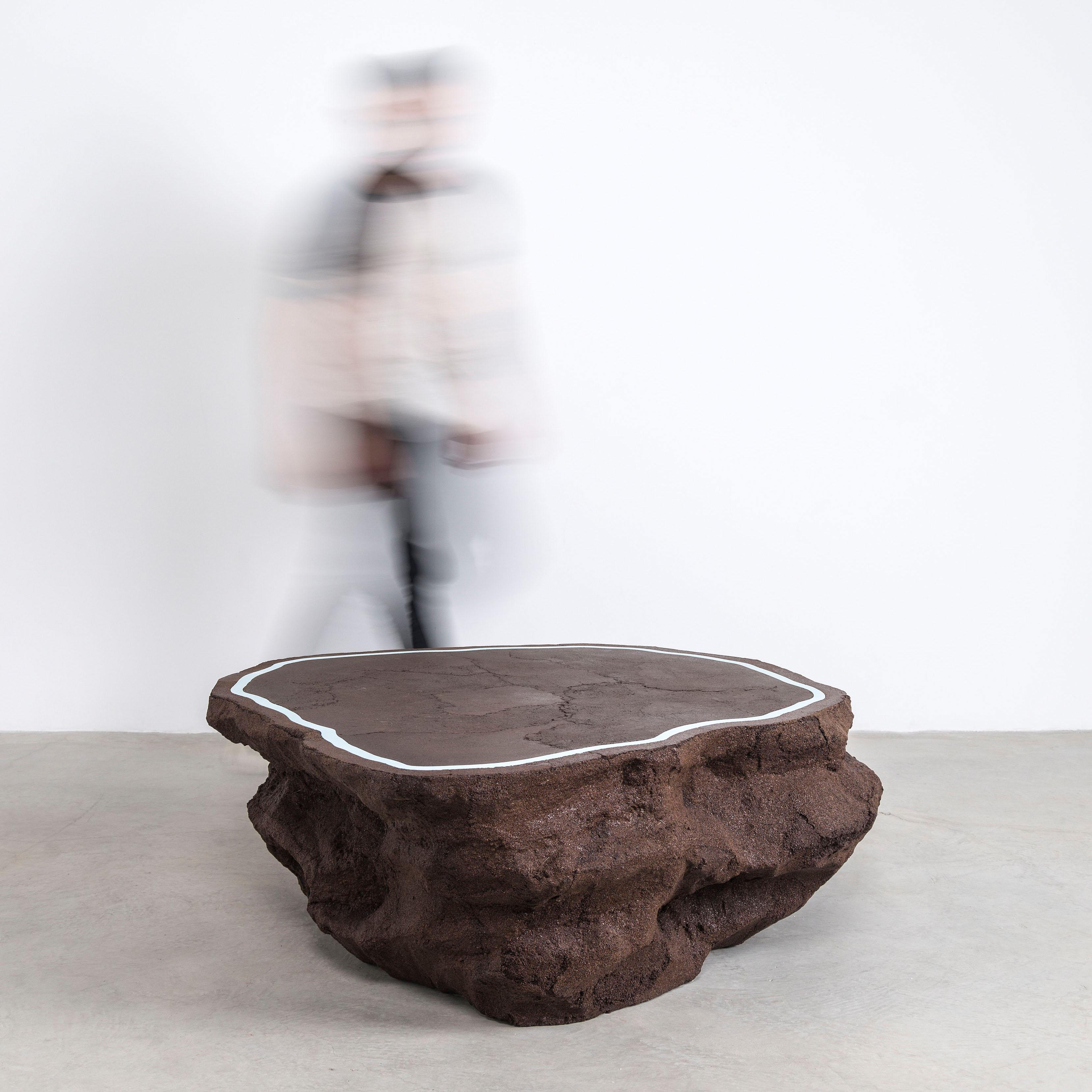 Composed in a language of landscape-oriented abstraction, the made-to-order coffee table is cast from entirely in coffee grounds. A humorous and striking combination, the organic, textural mass contrasts the slick, cement-inlaid top. 