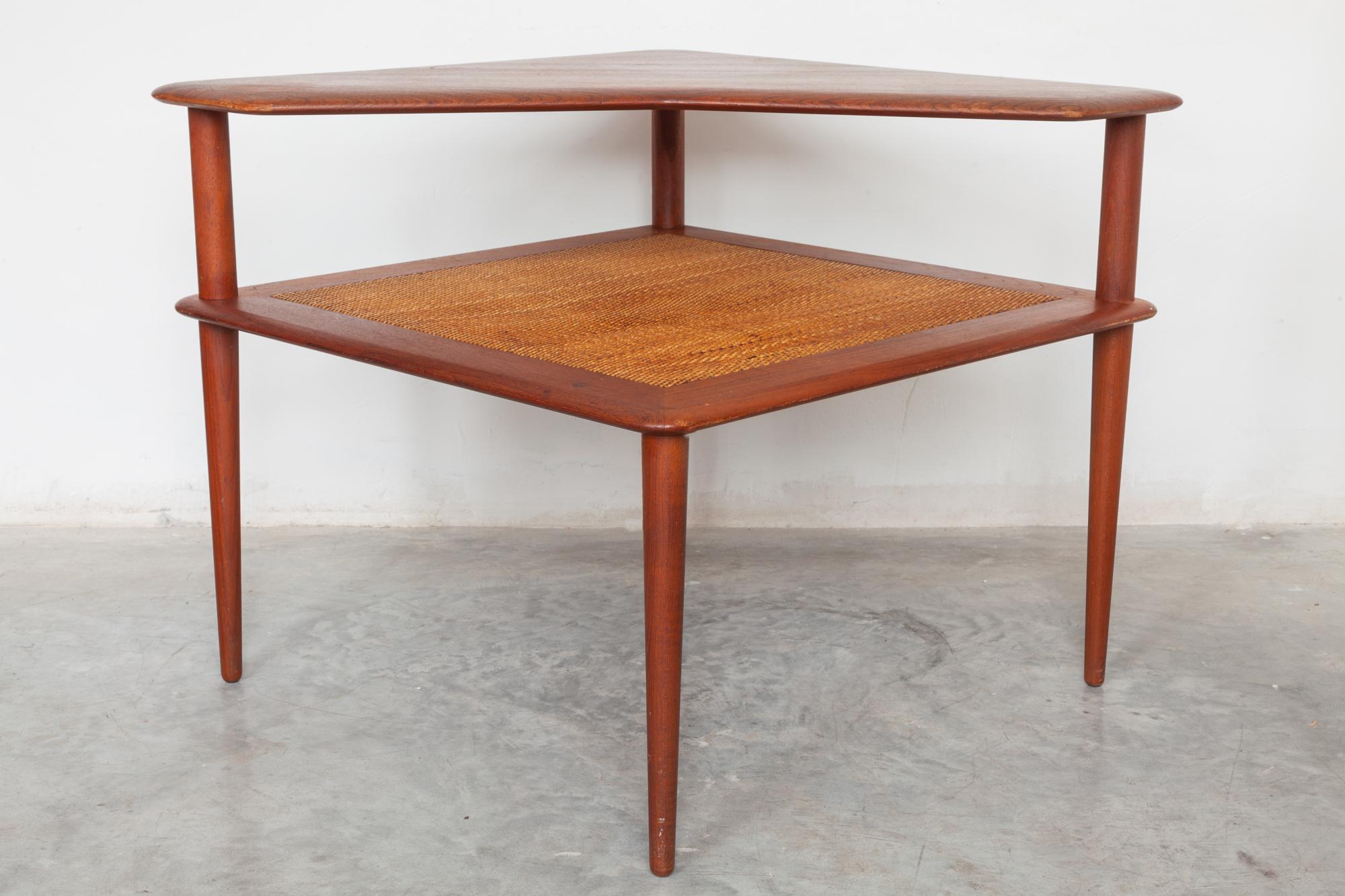 Midcentury teak corner table with woven rattan shelf. Excellent for use as a side
table or sofa table manufactured by France and Sons designer Peter Hvidt.