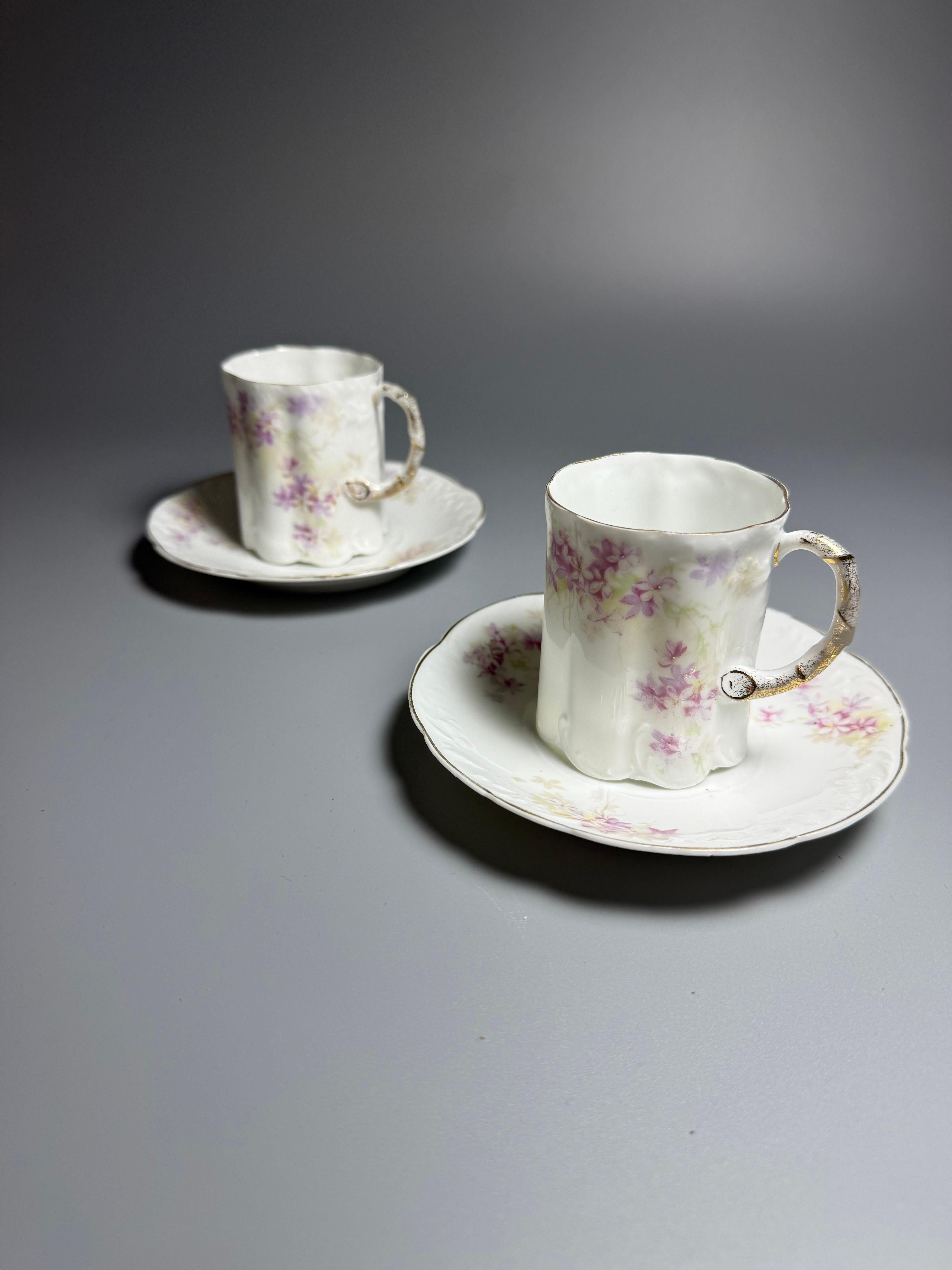 2 tasses à démitasse et soucoupes 
D 5,7 cm h 6,7 cm

Produit par la société Rosenthal en Bavière, Allemagne, principalement entre 1891 et 1906. 
Design :
La porcelaine blanche est ornée d'une bordure dorée et d'un motif floral, souvent rose et