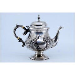 Coffee maker in embossed silver with floral motifs and a knob on the lid