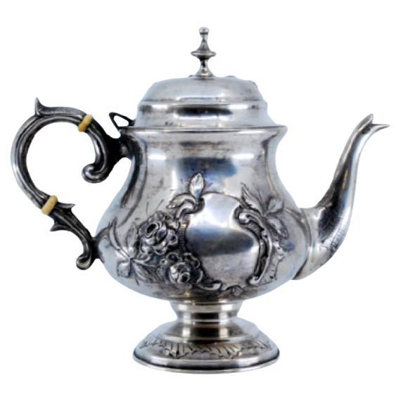 Coffee maker in embossed silver with floral motifs and a knob on the lid For Sale