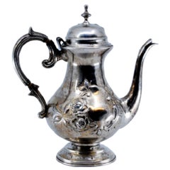 Coffee pot in embossed silver w/ floral motifs
engraved base
knob on the lid