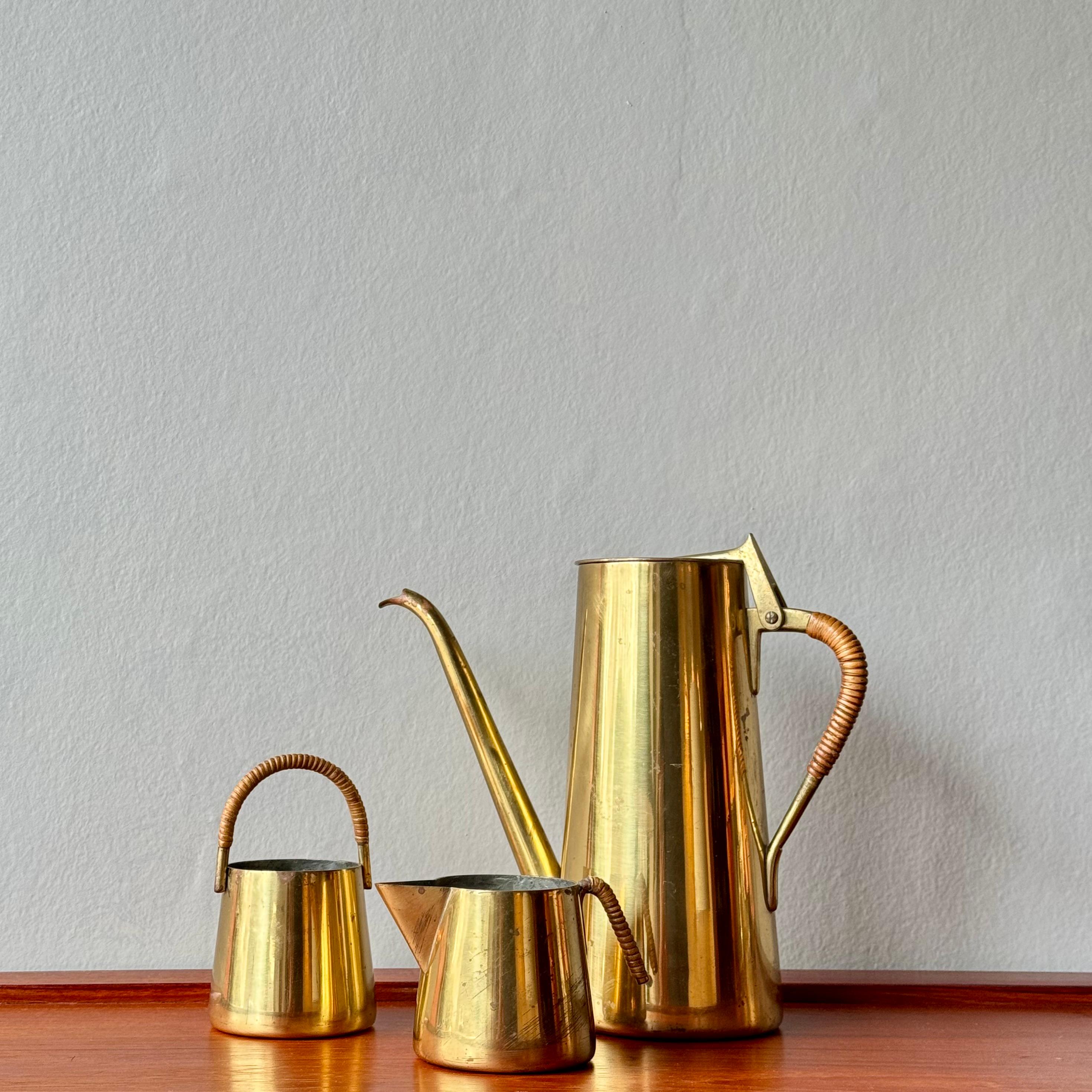 A three-piece brass coffee service with cane-wrapped handles, designed by Carl Auböck II during the 1950s. 

The contrast of cane wrapped handles with smooth brass is typical of the designs of Carl Auböck II during the 1950s. Both practical and