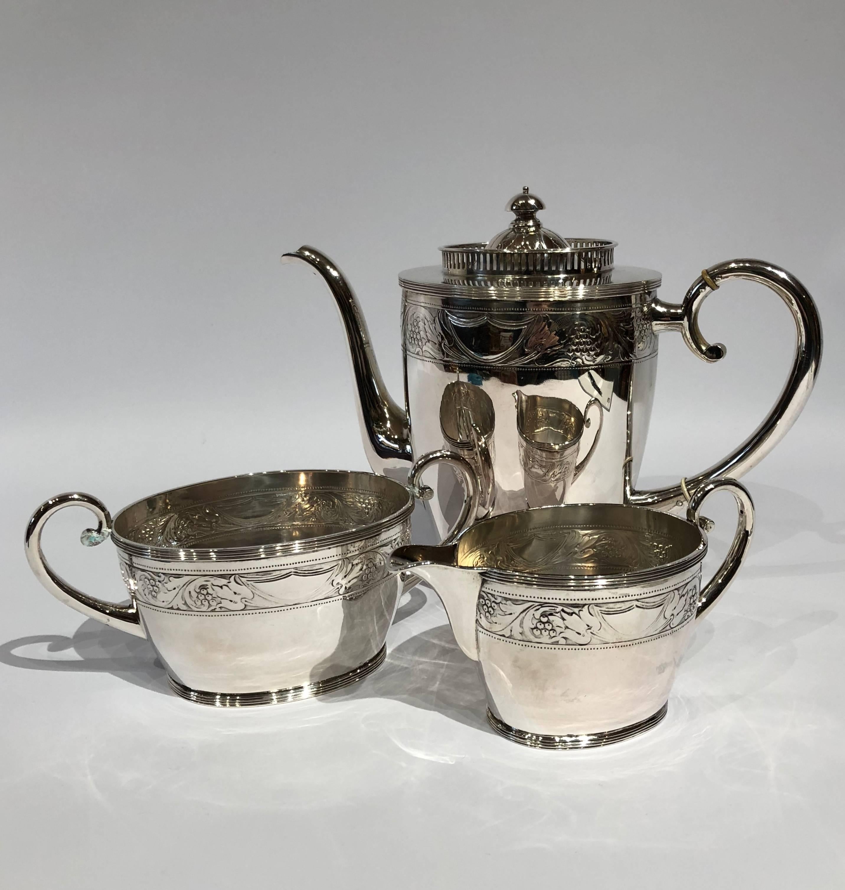 This coffee set comprises a coffee jug, sugar bowl, and cream jug, each adorned with intricate chasings. Crafted from hallmarked silver and stamped with the initials 
