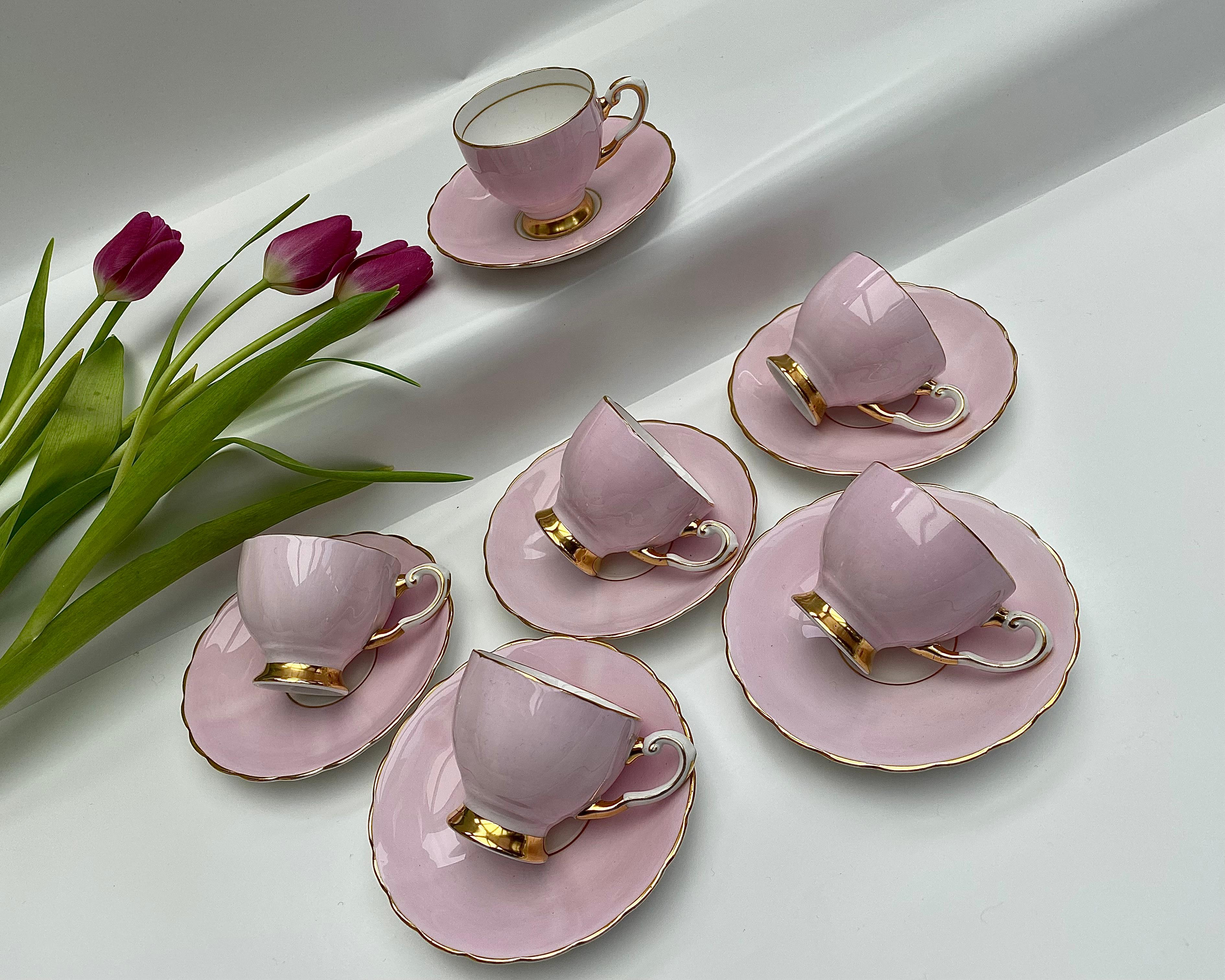 Elegant service à café de six pièces, fabriqué en porcelaine d'os anglaise immaculée.

Chaque pièce présente la beauté délicate d'un émail rose pâle, délicatement rehaussé de détails en or 24 carats.

Le luxe discret de cet ensemble, marqué