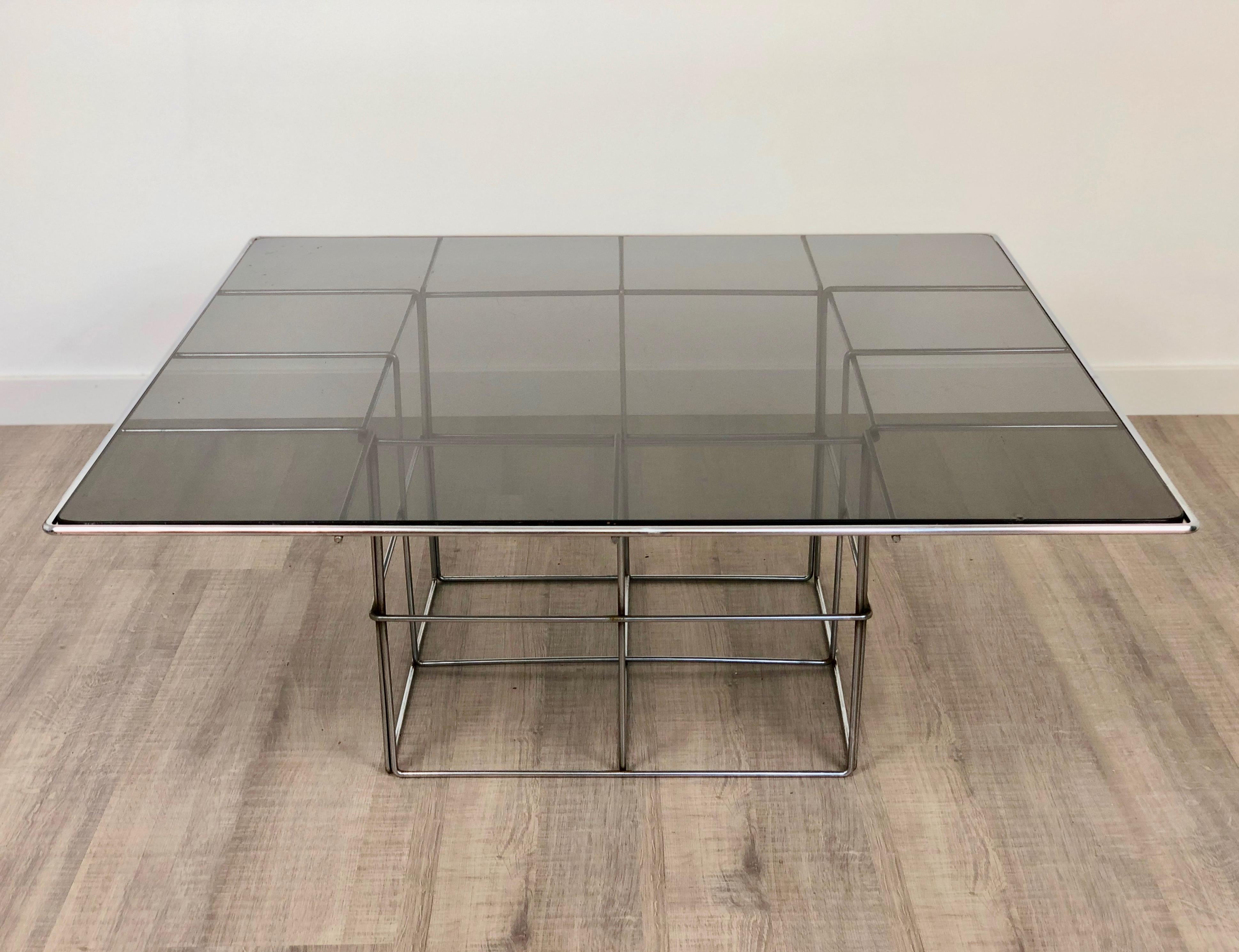 Table basse ou d'appoint de style Verner Panton avec une surface en verre fumé et une base en métal qui rappelle une cage.