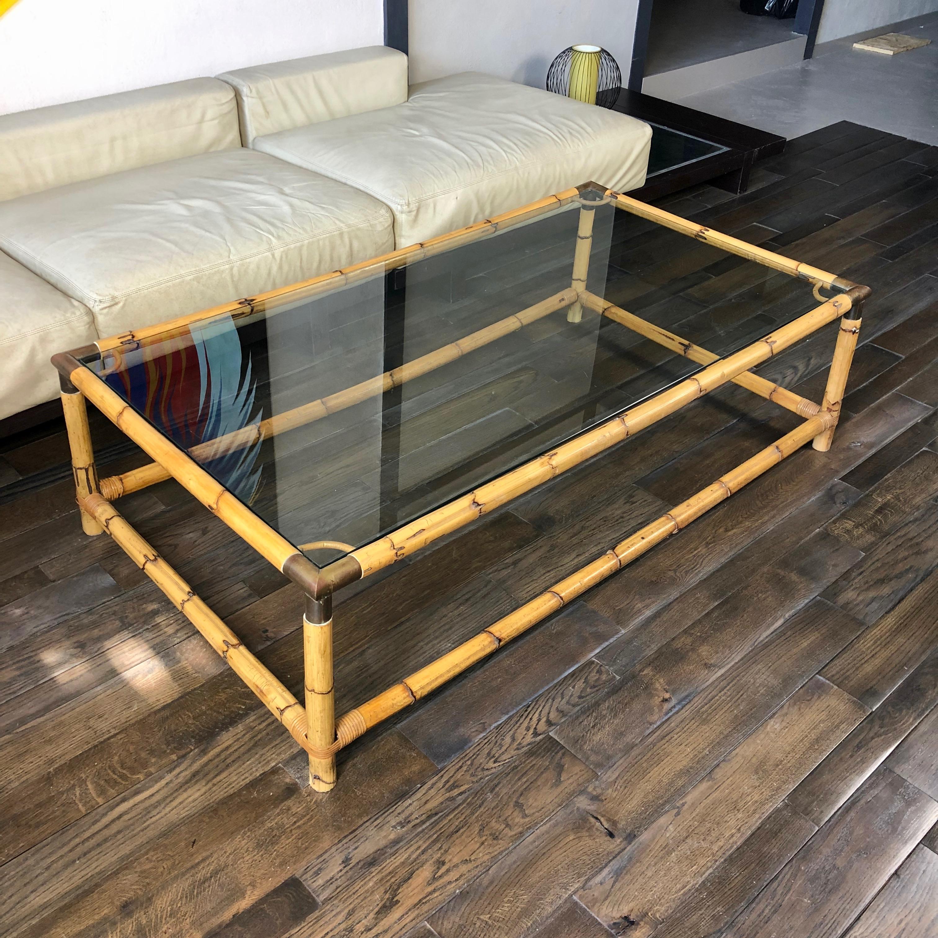 Rectangular coffee or side table in glass top and bamboo frame, with brass details in the corners. Italy, circa 1960.