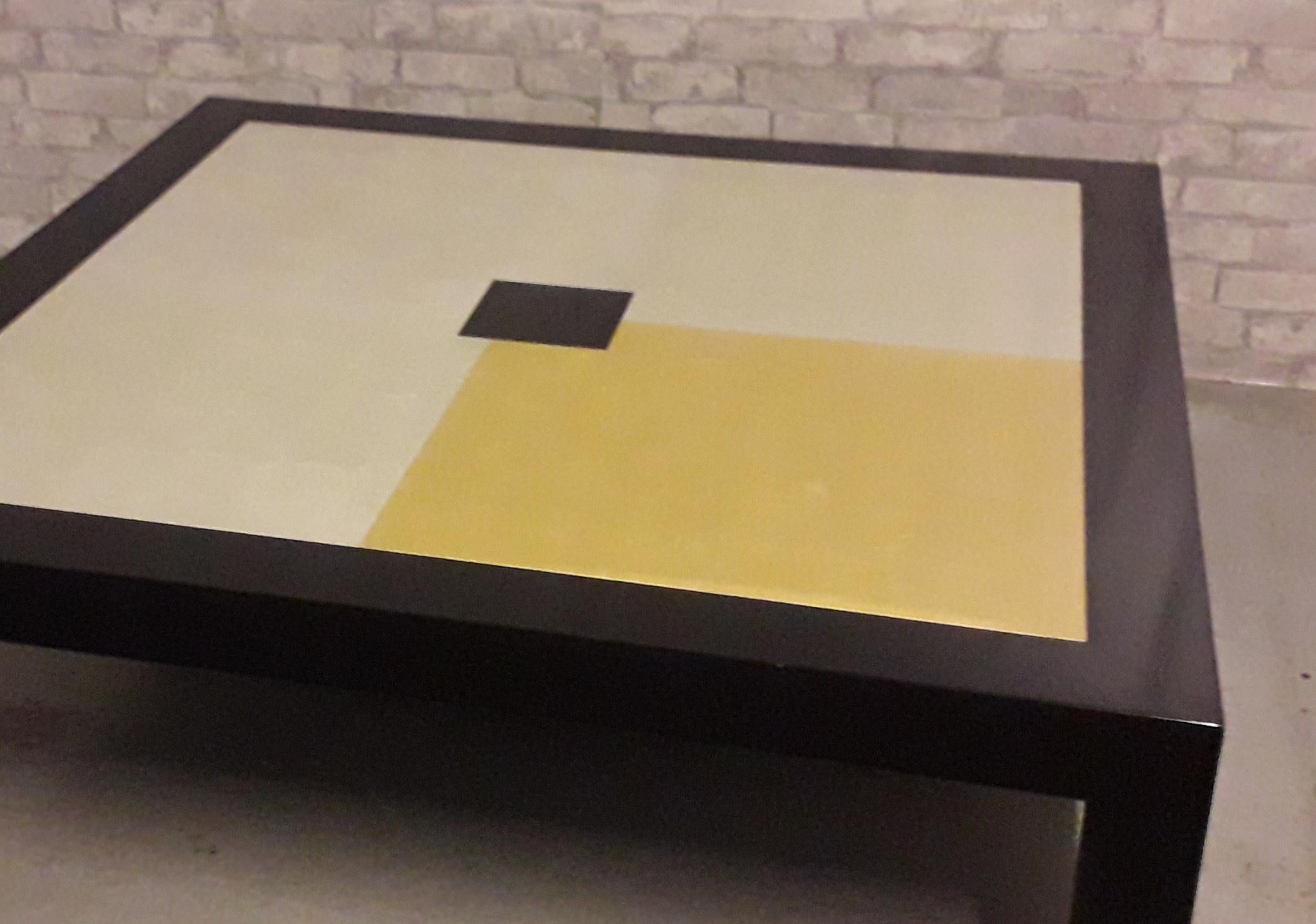 A modern design coffee table with four gilt varying panels of 12 - 22 Carat gold leaf, the ebonised frame all set on substantial square section legs.