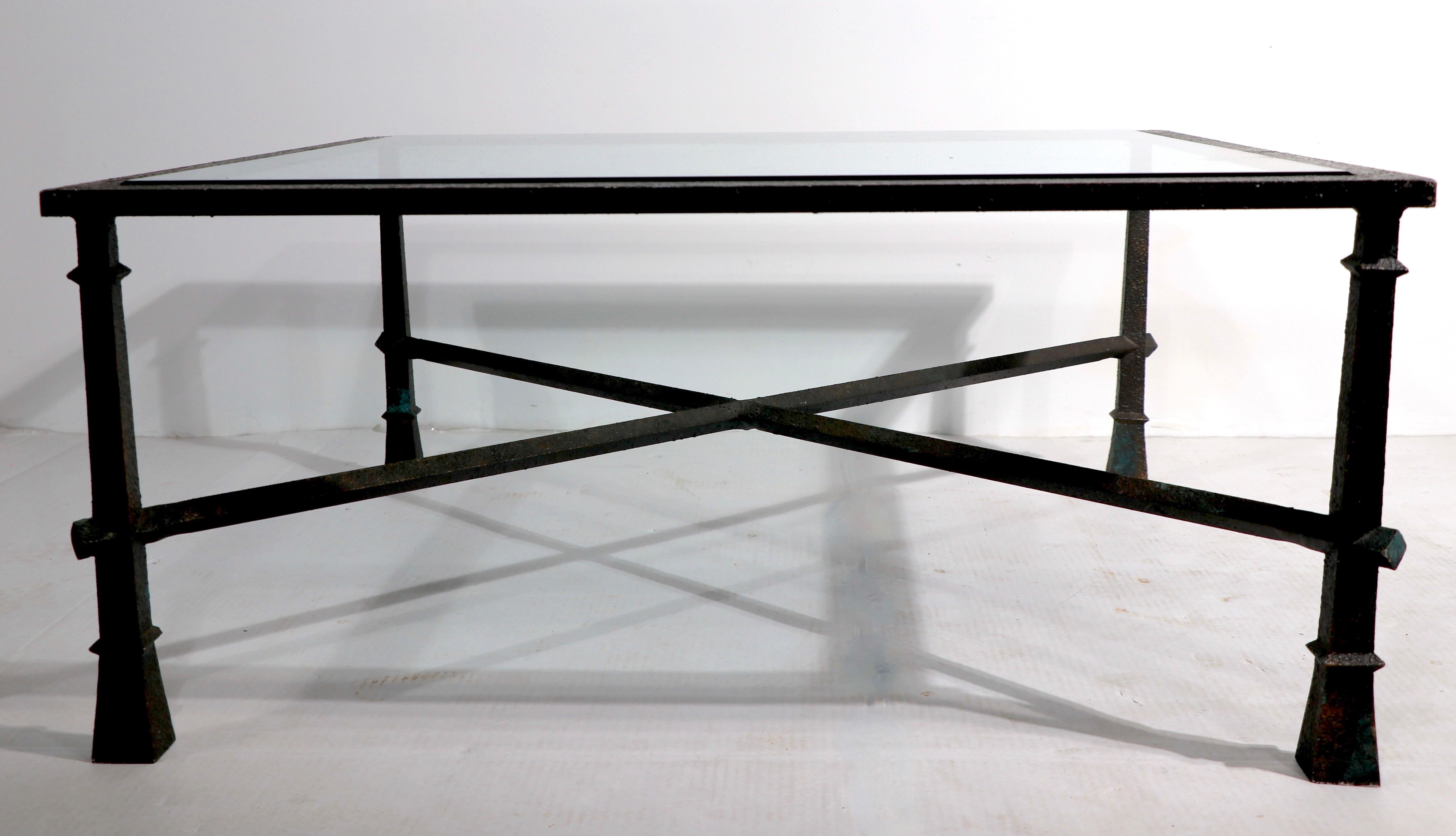 Chic architectural Brutalist coffee table in the style of Giacometti. The table has its original plate glass top, the frame is cast aluminum with faux finish. It is in very fine original condition, clean and ready to use.