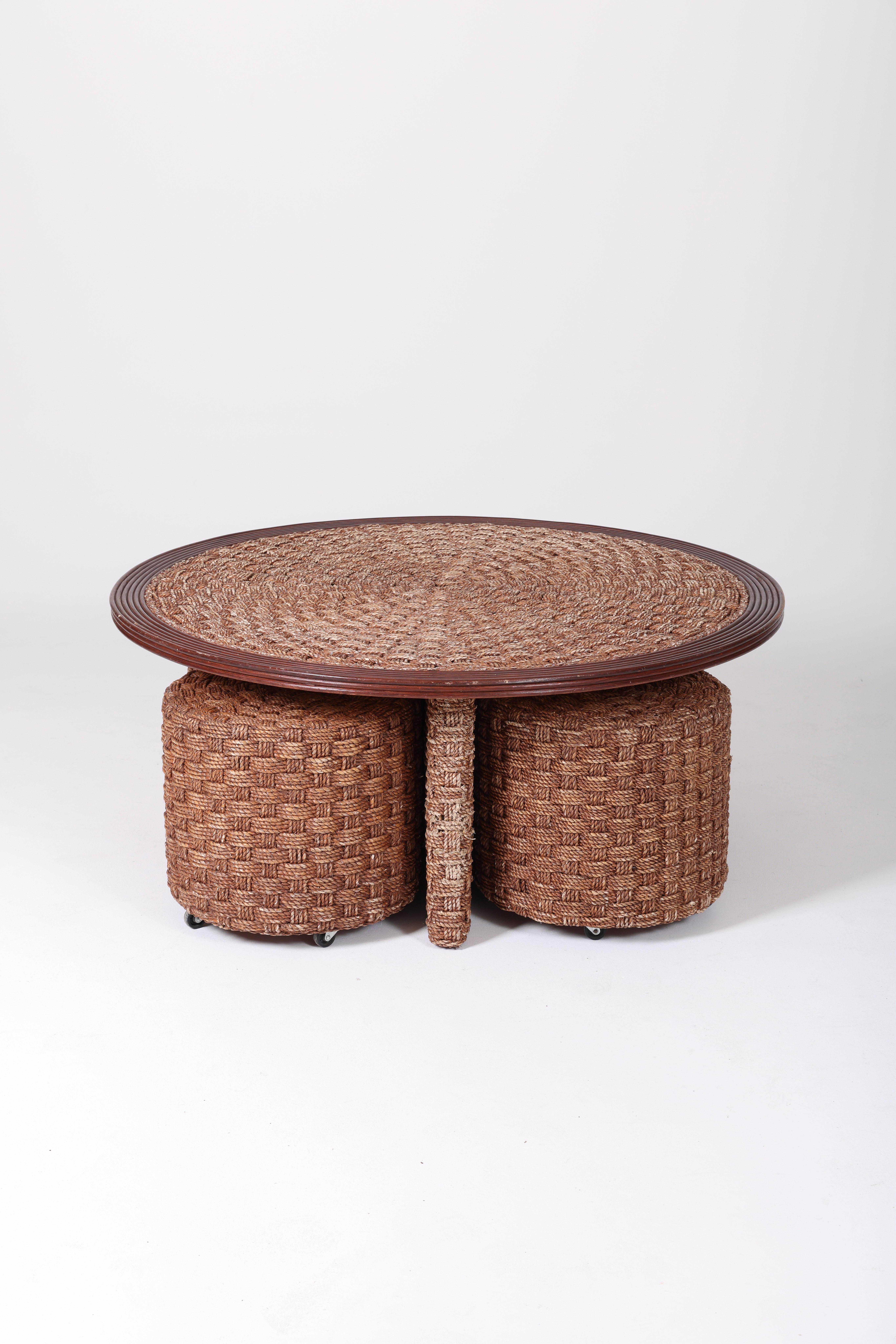 Living room in woven rope, 1970s. Round coffee table with 4 stools that slide under the table on casters. Slight traces of use on the table. Good condition.
LP998