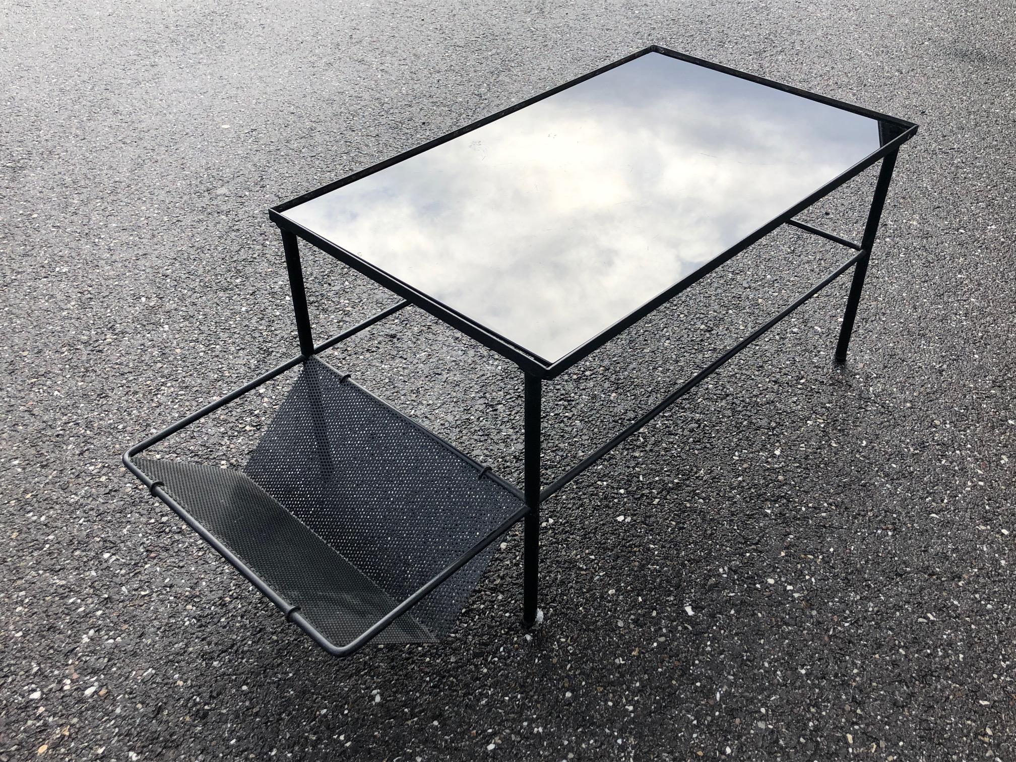 Coffee table from the 1950's, lacquered black metal frame and perforated metal magazine rack.
Table is top in black opaline.