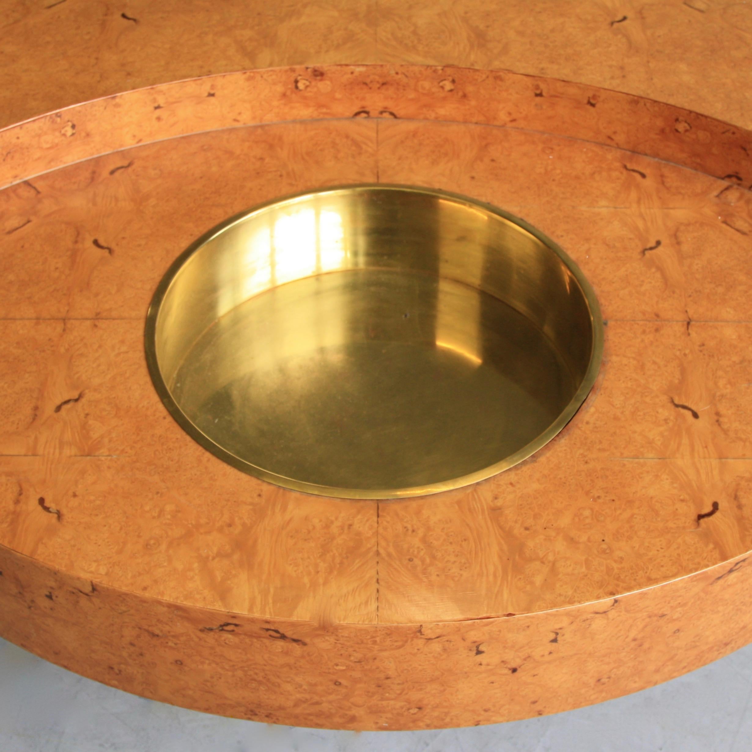 TRG (Tavolo rotondo girevole) round revolving coffee table designed by Willy Rizzo. Italy, Mario Sabot, circa 1974.

Wooden construction with burr wood veneer and brass colored round bucket insert. Signed by Willy Rizzo on the side of the