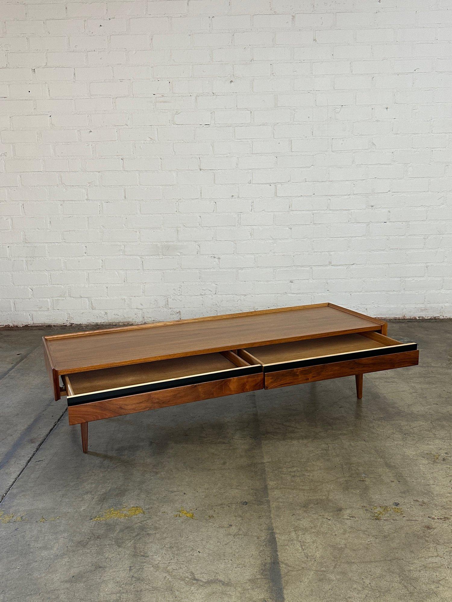 W60 D19.5 D19 H15

Fully restored walnut coffee table by Dillingham. Item offers a great minimal low profile with subtle details. Coffee table has tapered legs, a risen back edge surface,  black accents, and minimal hidden pulls for drawers. Item is