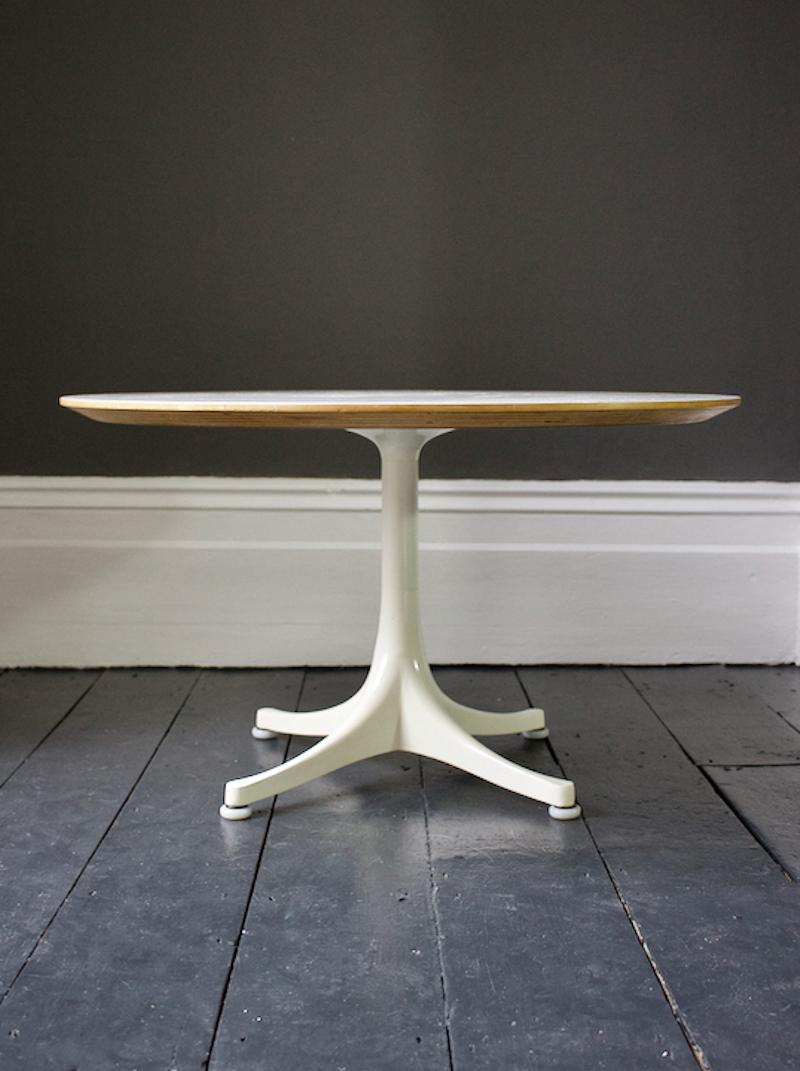 Simple and elegant coffee table designed by George Nelson in the 1960s for Herman Miller.

This model has a white laminate top - with nicely chamfered edge revealing plywood layers below - on an off-white enamelled four-star base. Manufactured by