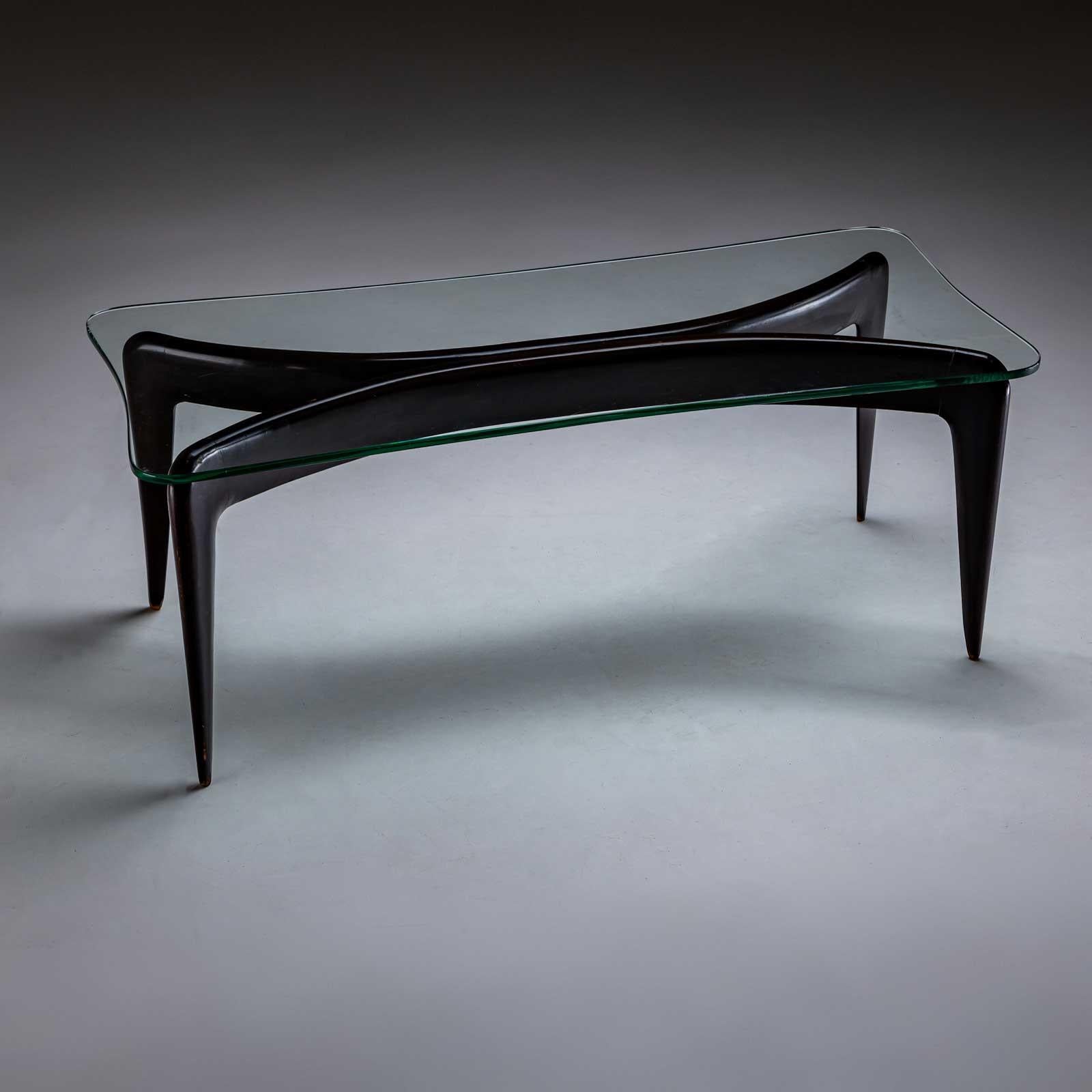 Table basse italienne du designer et architecte italien Giò Ponti (1891-1979) sur des pieds coniques noirs et un cadre élégamment incurvé. Le plateau en verre repose sur cette base et présente une forme concave correspondante.