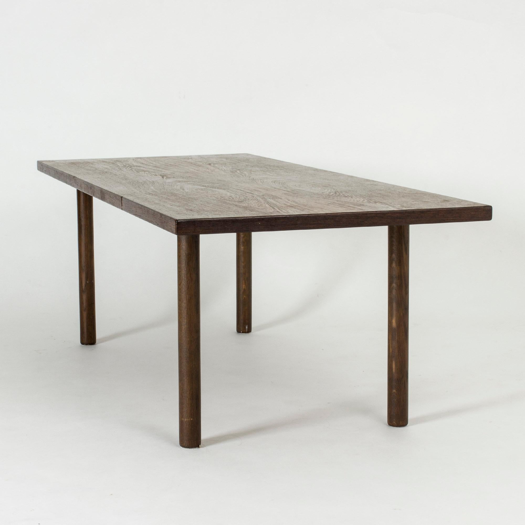 Table basse de Hans J. Wegner, au design épuré et équilibré. Plateau de table en wengé et pieds ronds en chêne teinté.