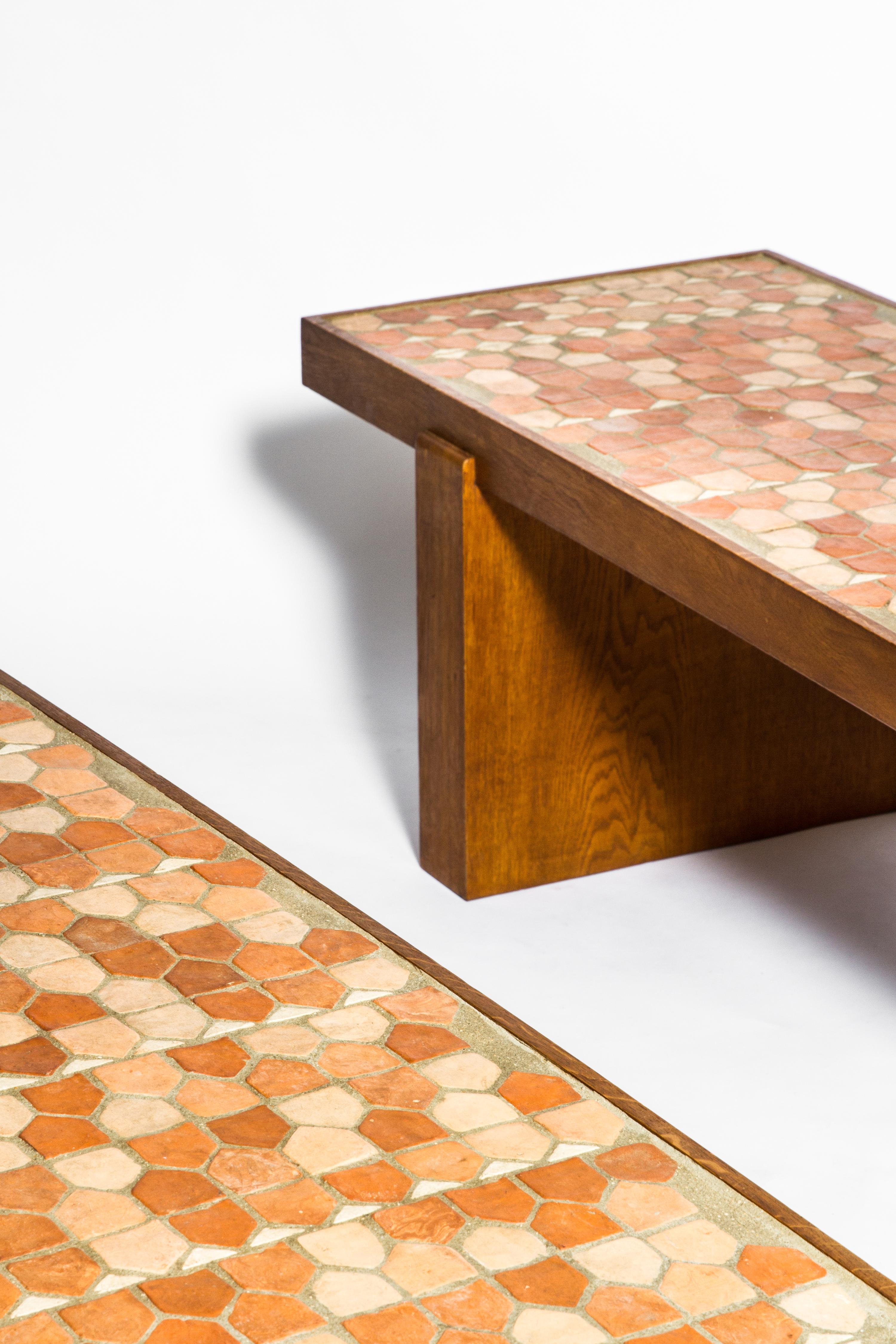 Pair of coffee tables by Jacques Adnet and Jacques Lenoble with ceramic top, circa 1950. 
Solid oak structure and terra cotta tiles for the top. 
These low tables are a collaboration between Jacques Adnet and Jacques Lenoble for La Compagnie des