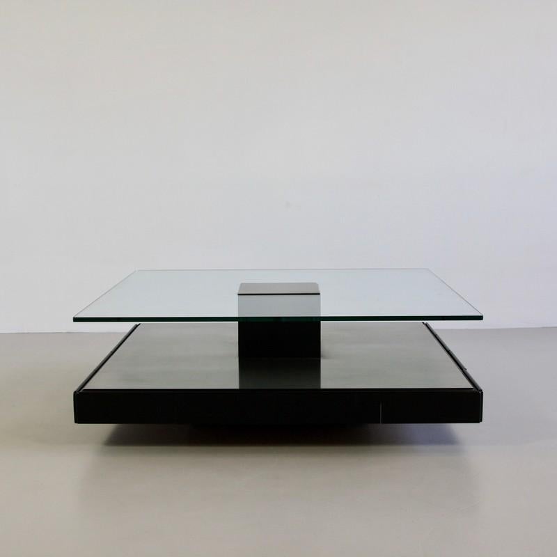Large coffee table designed by Marco Fantoni. Italy, Tecno, 1971.

Minimalist coffee table (Tecno T147) with brushed metal base on wood containing eight drawers, thick glass shelf with brushed metal insert. Tecno labels on glass and all drawers.