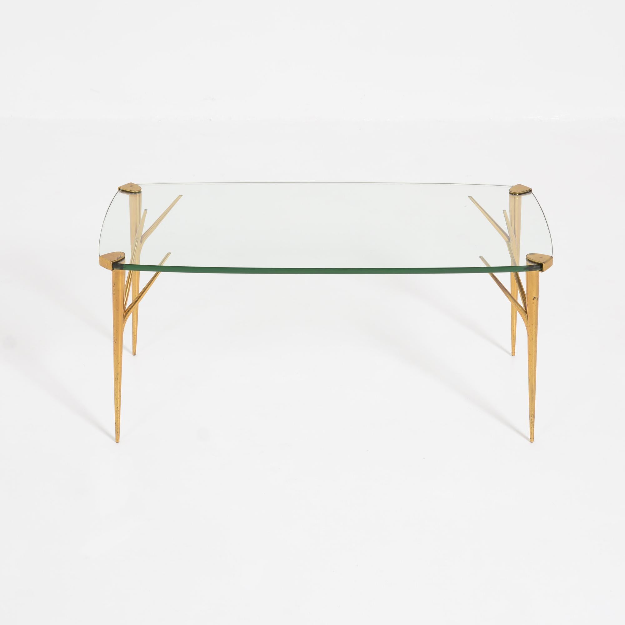 This beautiful coffee table was designed by Max Ingrand and manufactured by Fontana Arte in 1956.
The elegant brass legs support the rectangle crystal glass top.
This table is in good authentic condition, the glass top has a tiny chip, visible in