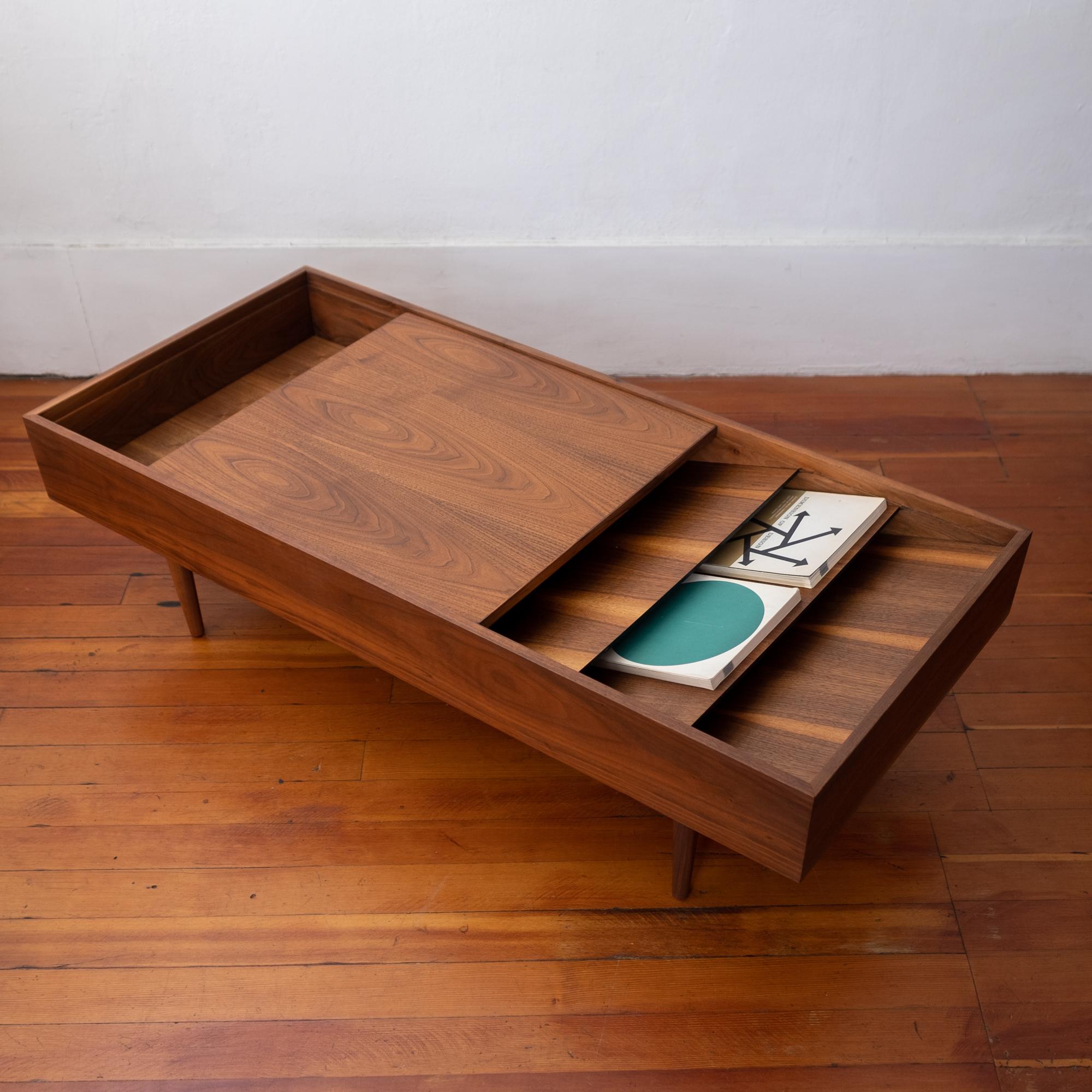 Walnut coffee table by Milo Baughman for Glenn of California. One side is for magazines and the other side reveals a divided storage area. The top can slide to cover either side.
  