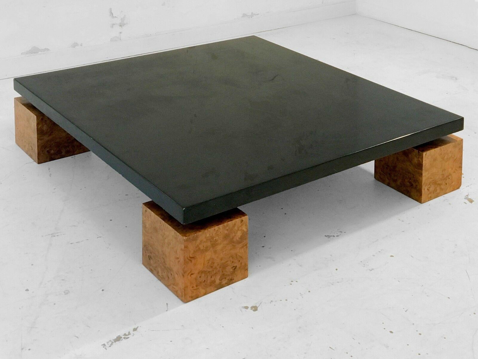This very large square coffee table by Nadine Charteret is a composition of 4 cubic legs wood plated in elm burl, and a large black-lacquered wooden tray. The spirit of seventies, but also 1980's Memphis Italian style characterizes this piece made