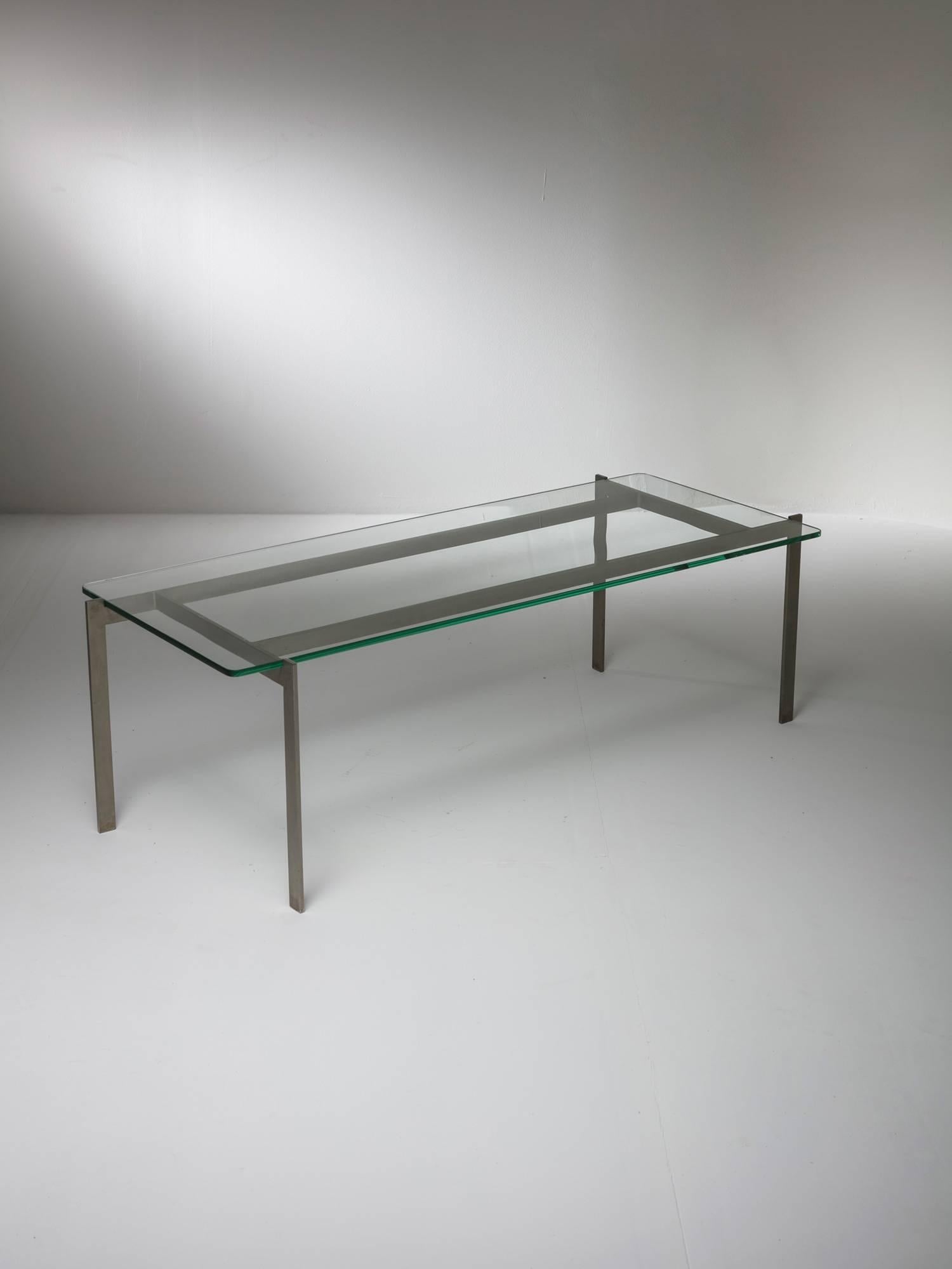 Low table by Paolo Tilche for Arform.
Thick glass top locked to the metal frame visually connected to Poul Kjaerholm design.