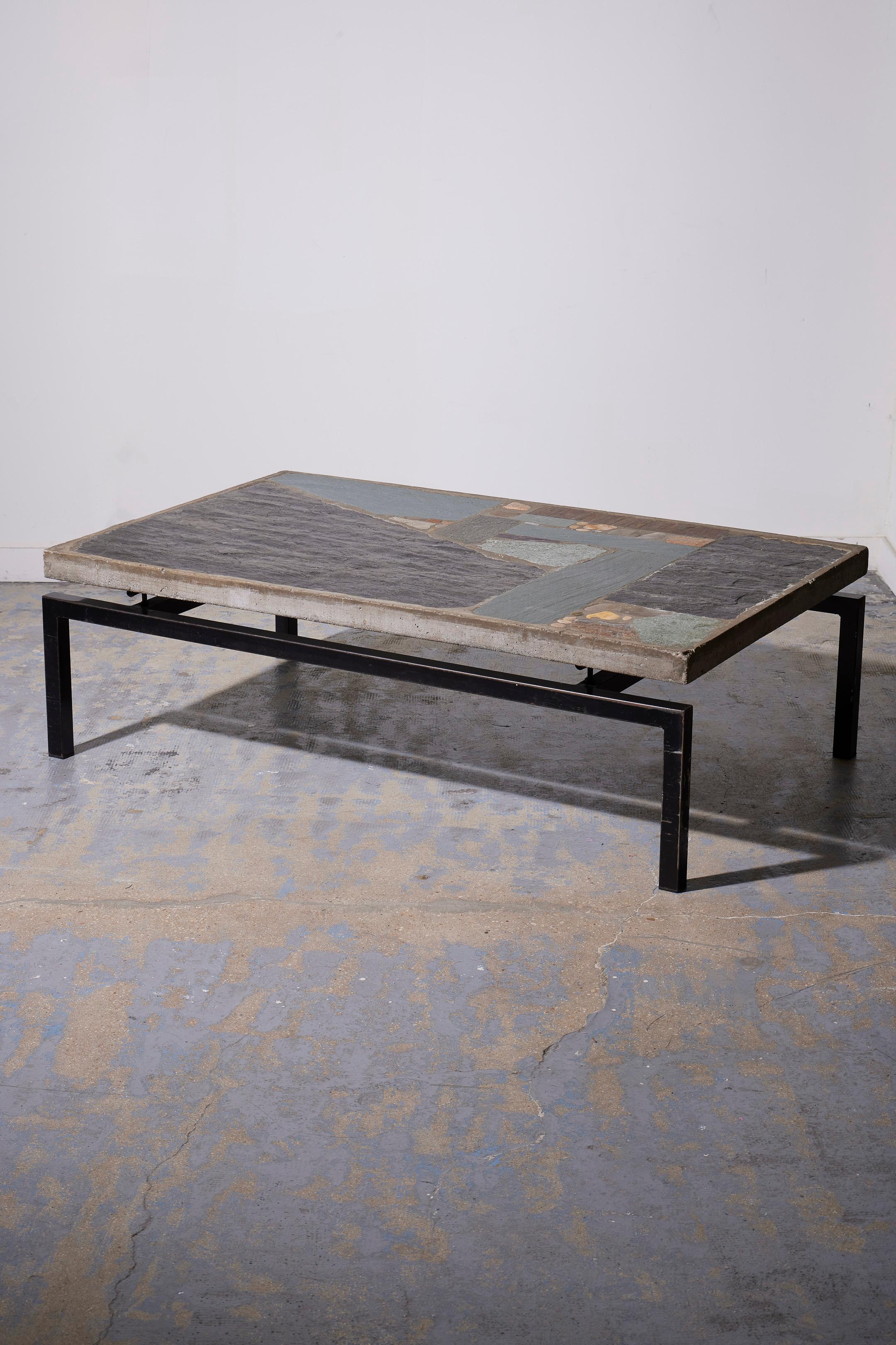 Coffee table by Dutch designer Paul Kingma (1931-2015) in the 1960s (1965). All his tables are unique creations. The table has a black metal structure supporting a floating concrete panel tabletop with inlays of slate and various stones. Beautiful
