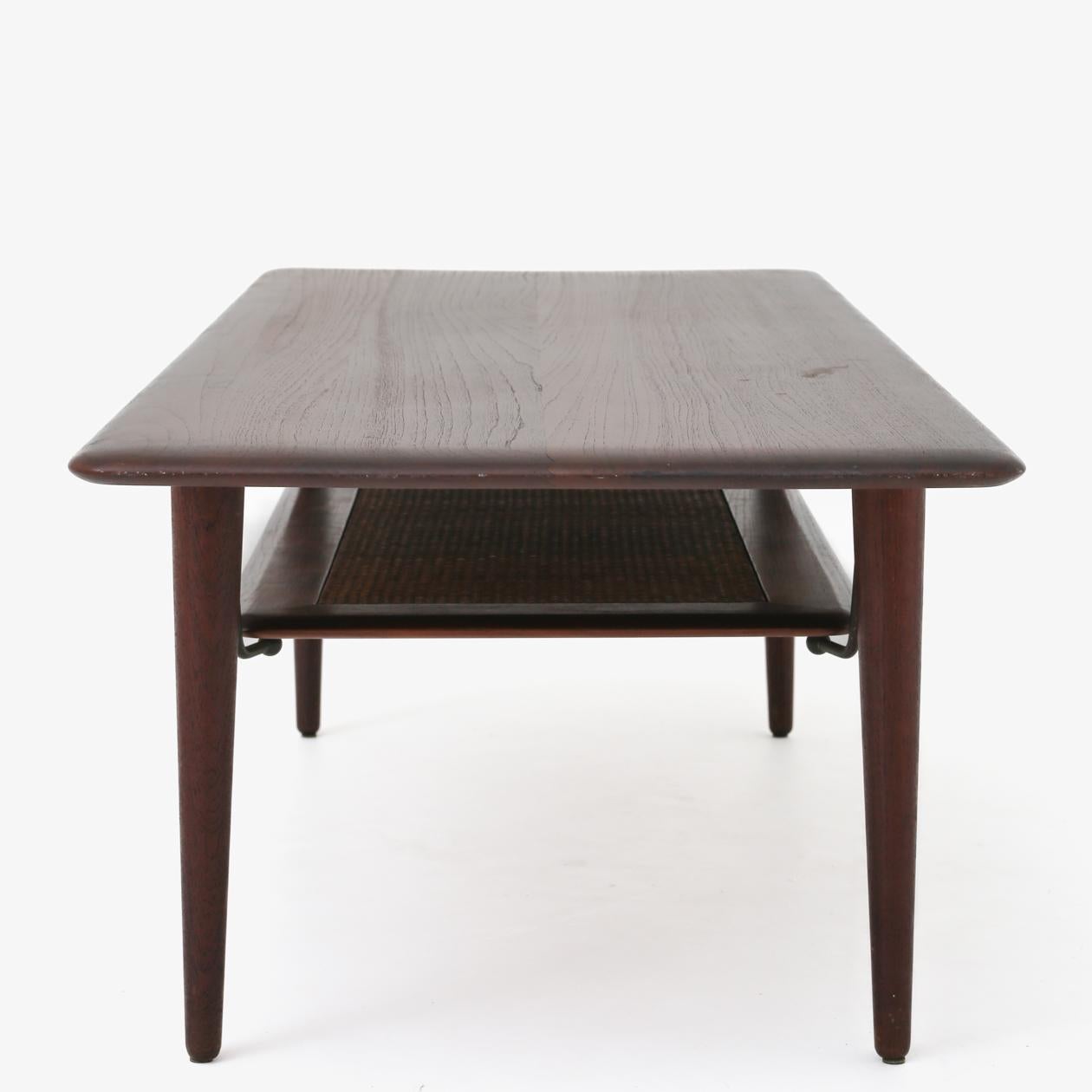 Coffee table with solid teak top and underlying shelf in cane. Peter Hvidt & Orla Mølgaard / France & Son.
