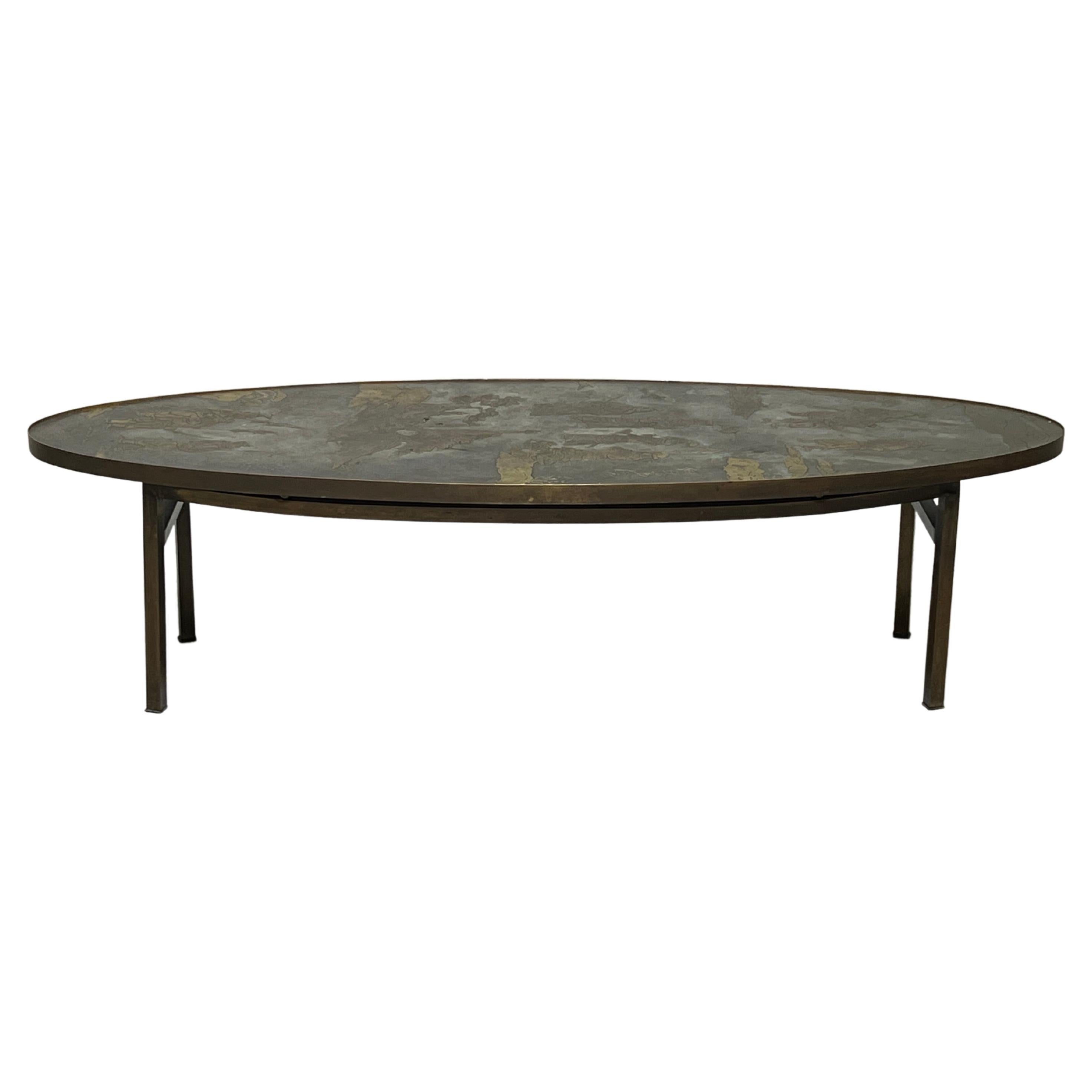 An oval etched bronze coffee table designed by Phillip and Kelvin Laverne.