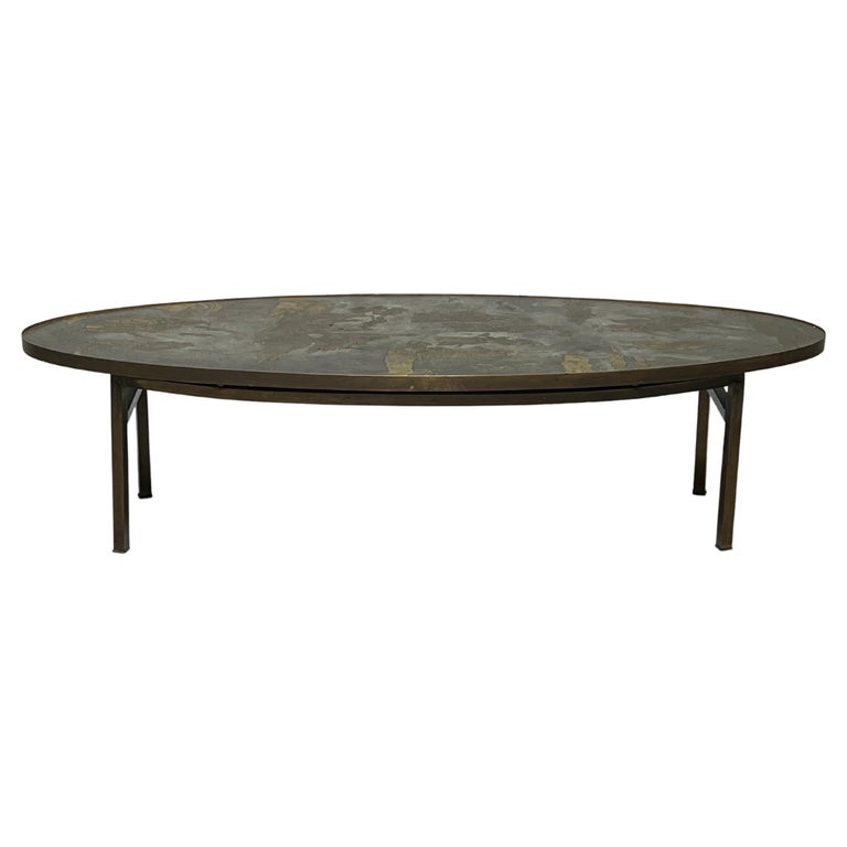 An oval etched bronze coffee table designed by Phillip and Kelvin Laverne.