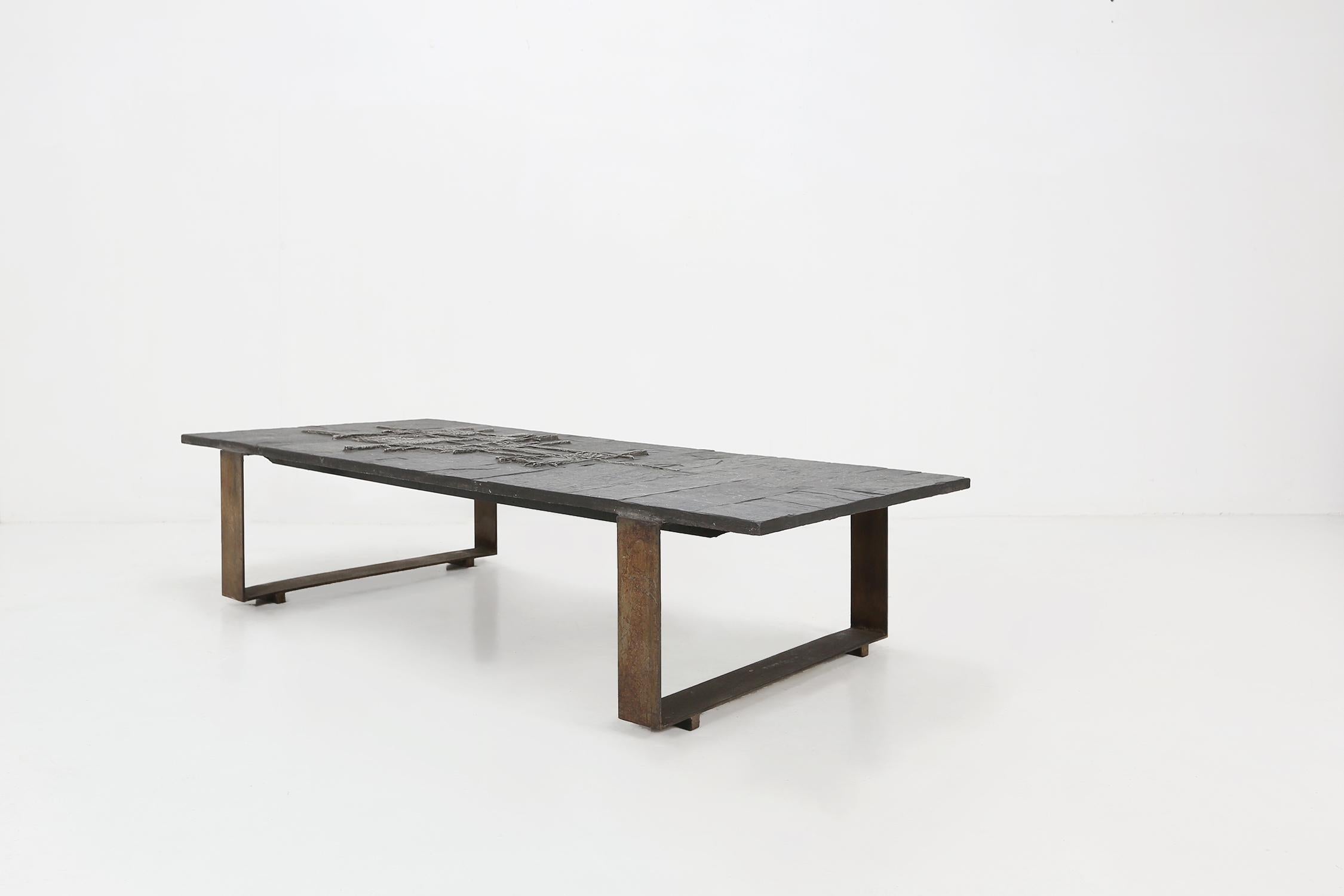 A unique handmade coffee table made by Pia Manu, Belgium, 1960. The table top is made of Brazilian slate stone with a subtle tones of black an grey. In the middle of the top we find a decorative yet abstract sculpture in tin metal. The base is made