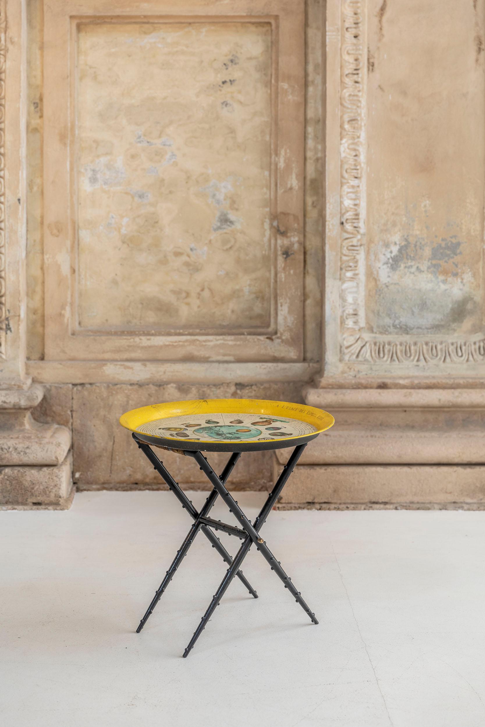 Brilliant yellow coffee table attributed to Fornasetti. Yellow and multicolor top tray with the iconic dirigible and hot-air balloons theme. The below structure is a dark wood decorated stool with original silk and brass details.
  
