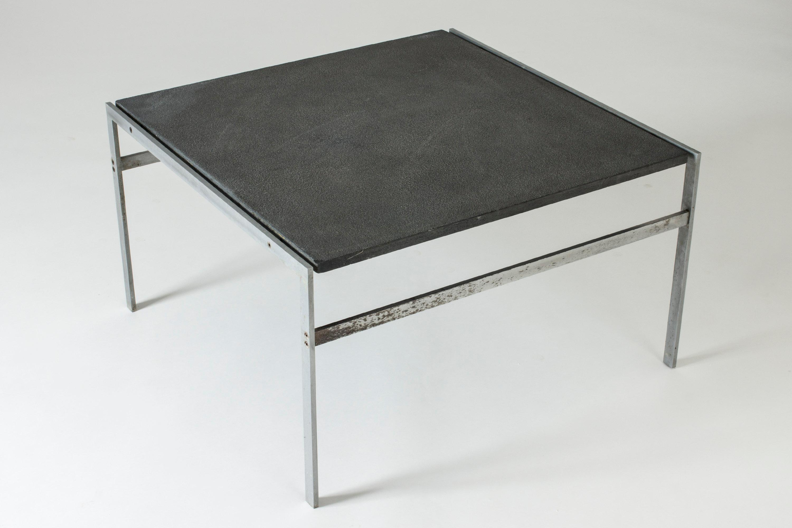 Cool coffee table by Preben Fabricius & Jørgen Kastholm, made from a crisply cut steel frame and a grey, structured stone tabletop.