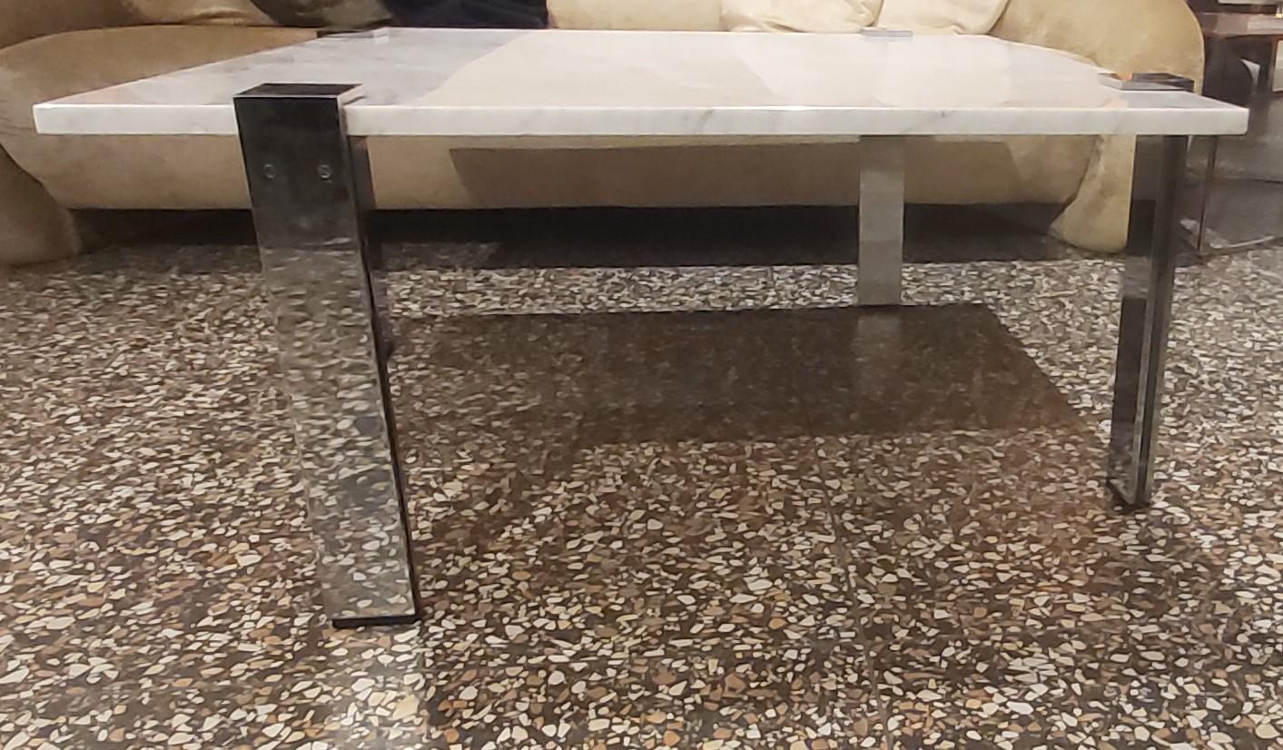 Vierbeiniger Couchtisch mit leichten L-förmigen Beinen aus verchromtem Stahl von Reto Frigg, die eine Platte aus Carrara-Marmor umschließen. 
Originelles und wunderschönes Design. 


