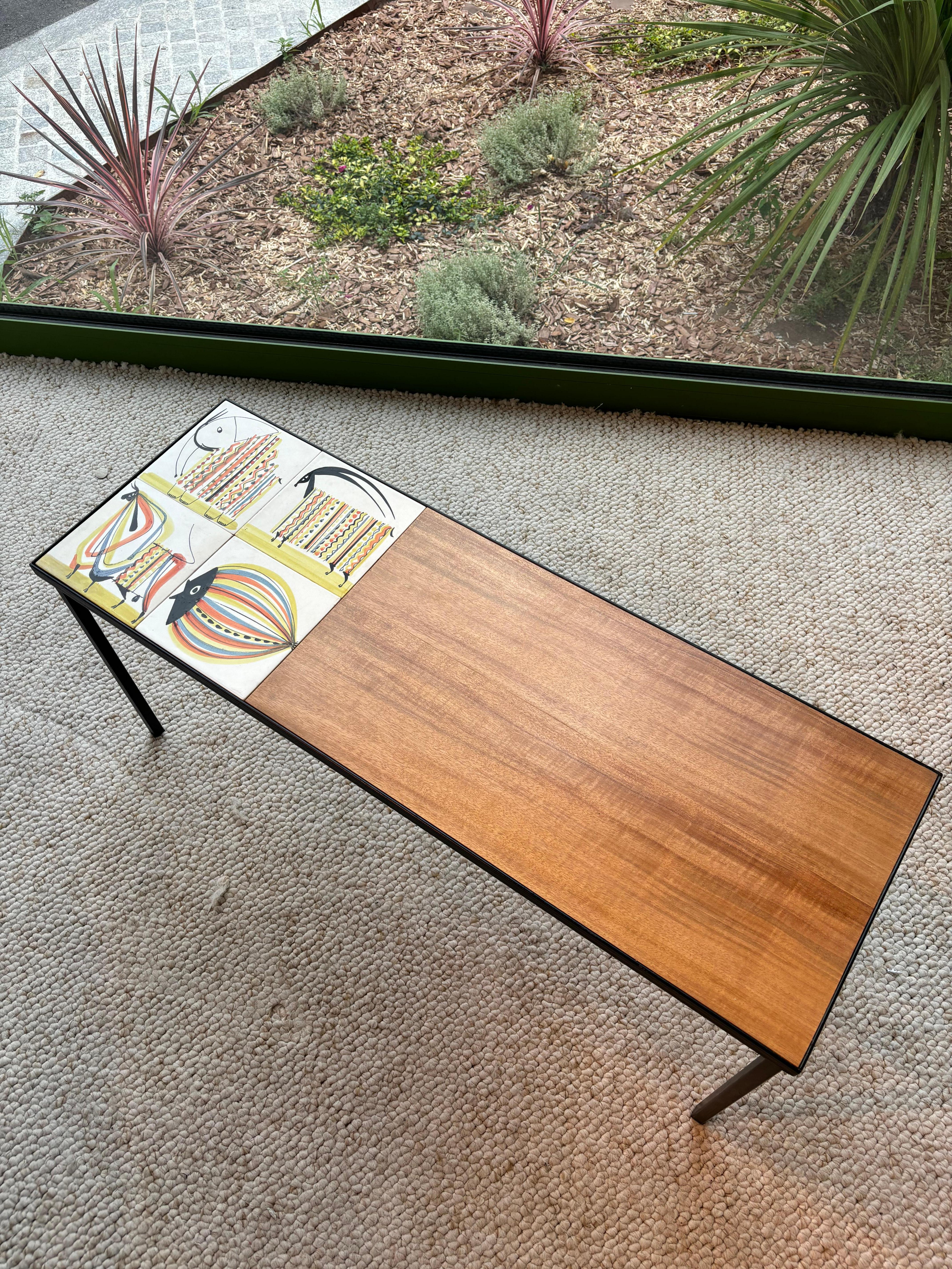 Table basse par Roger Capron, elle est composée de quatre carreaux figuratifs et de teck. 