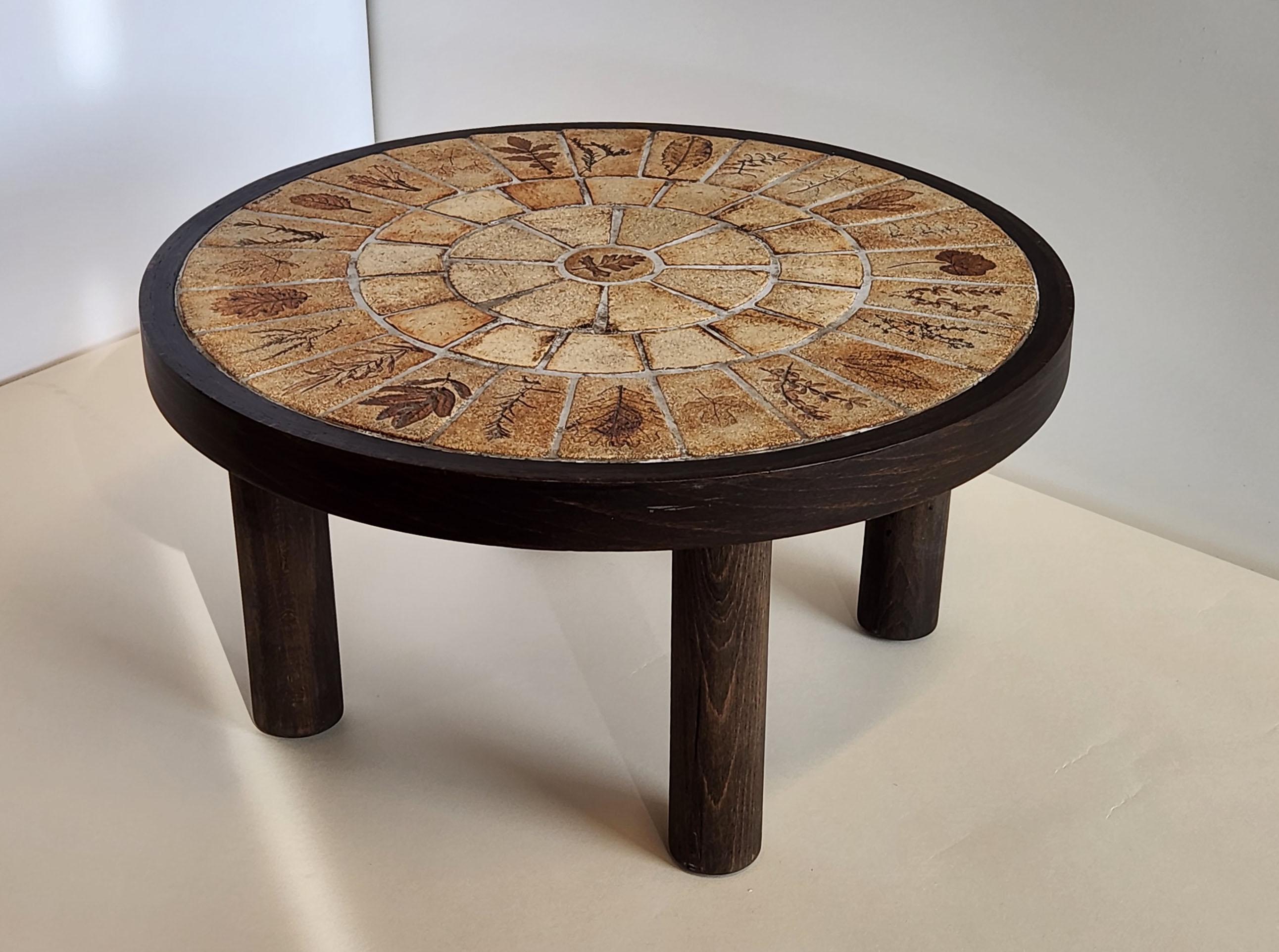 Round end table with the famous Roger Capron Herbier tiles, designed  from 1968 to 1982.

The handcrafted Garrigue tiles produced by a technique in which real leaves were pressed into the clay and, during firing, disintegrated, leaving a finely