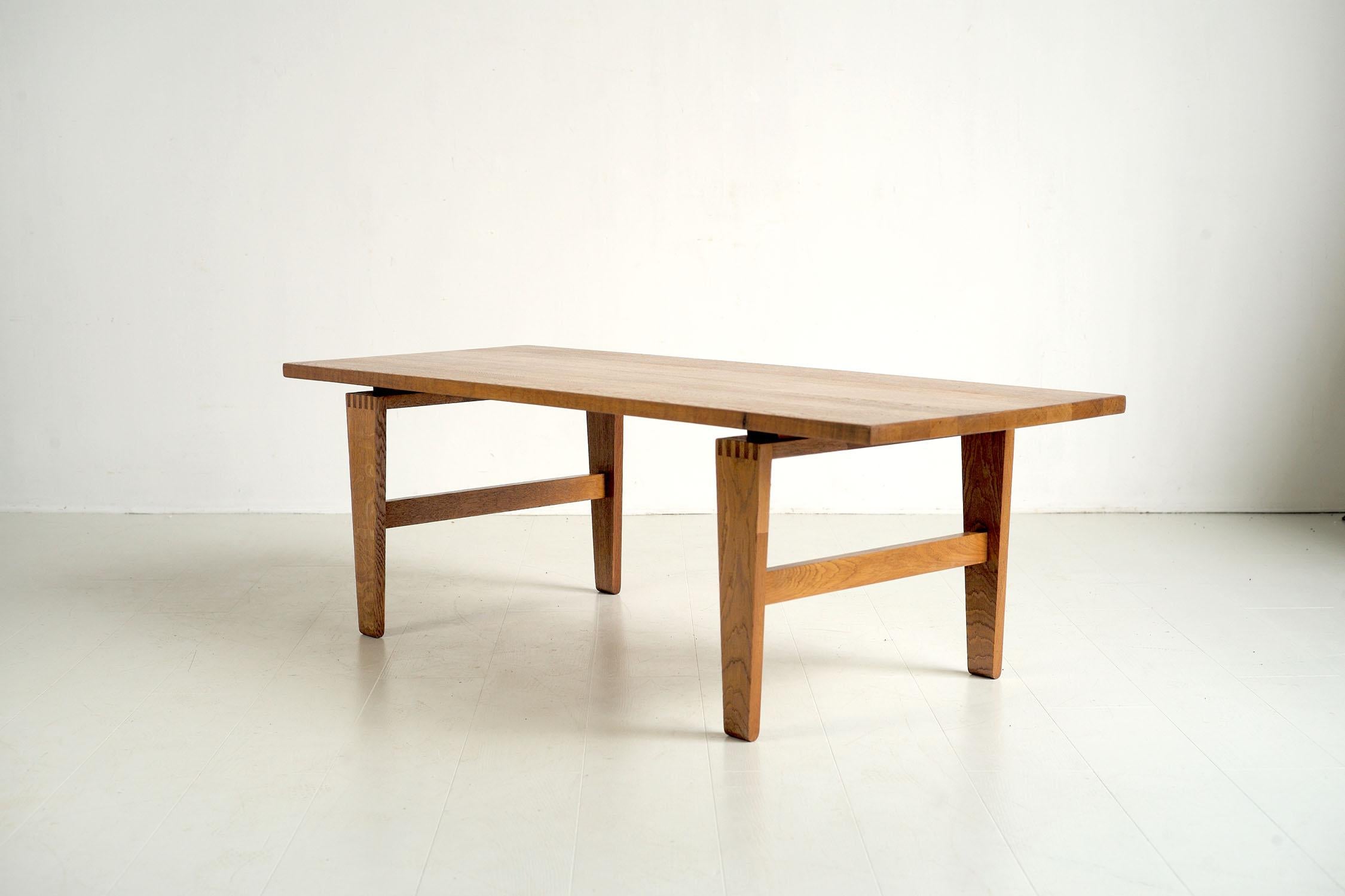 Grande table basse en chêne par Stolefabriken Odense, Danemark 1960. Le plateau est constitué de lattes de chêne blond, la base, détachée par une pièce de bois intercalaire, est décorée d'un assemblage 