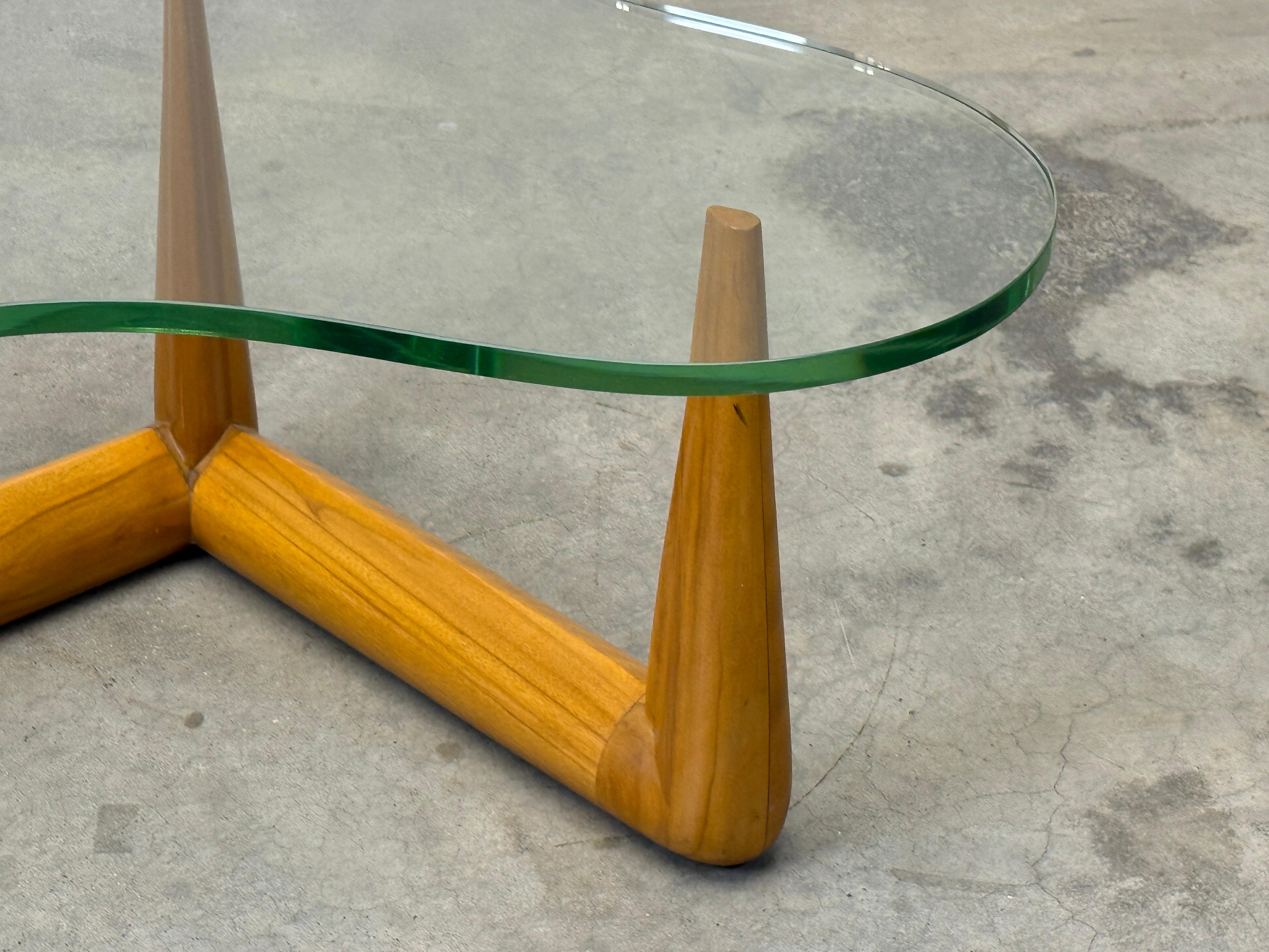 A glass top biomorphic coffee table with bleached walnut base. Designed by T.H. Robsjohn-Gibbings for Widdicomb. 